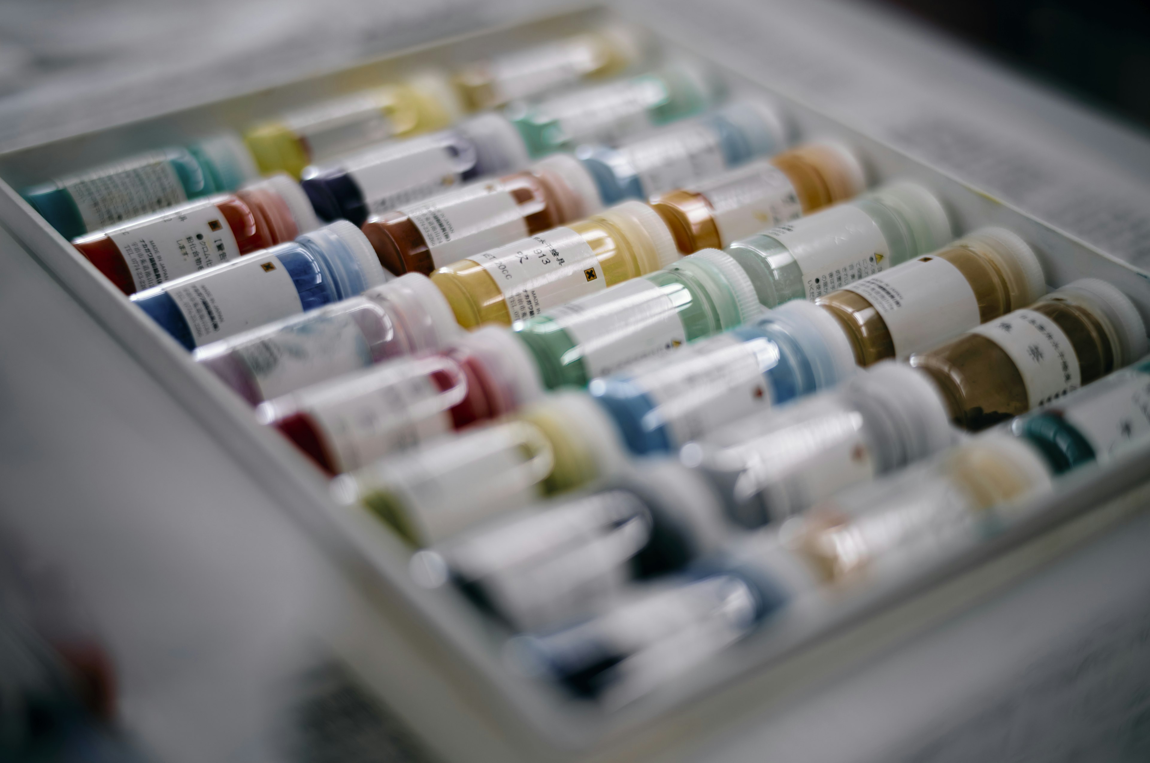 Colorful paint tubes neatly arranged in a tray