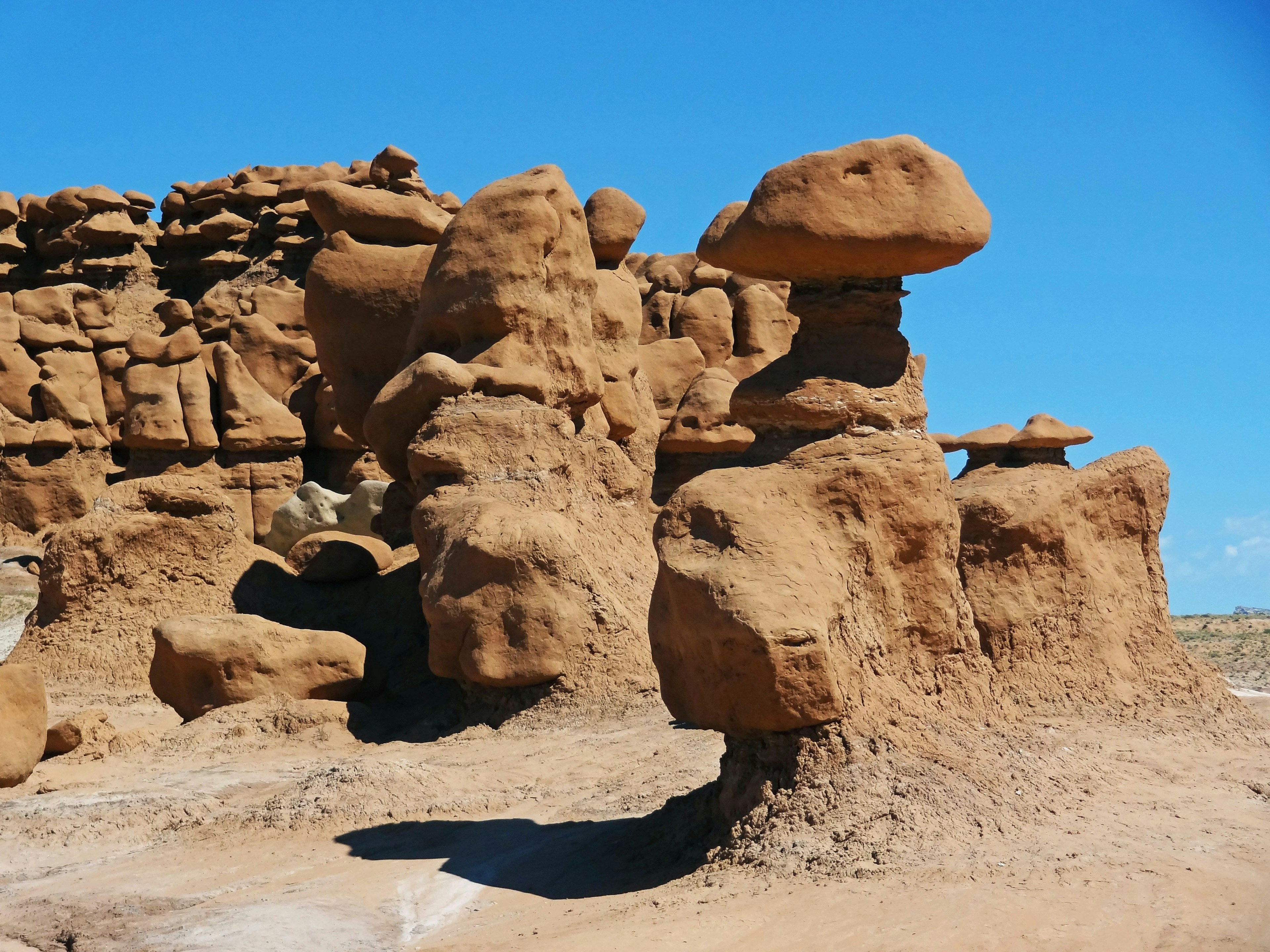 Unique rock formations in a desert landscape under a blue sky