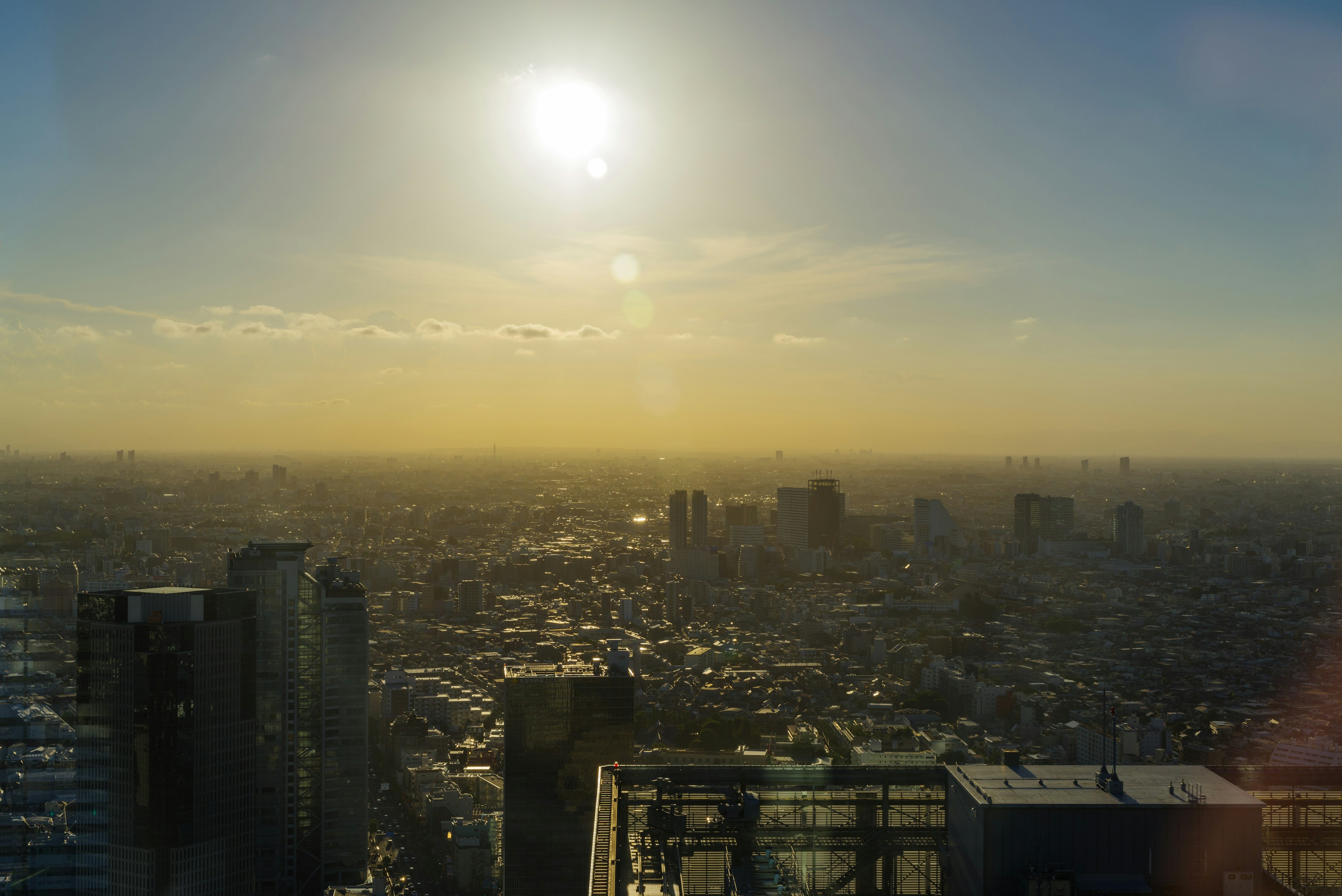 从摩天大楼俯瞰城市的全景日落时的太阳和天空中的云