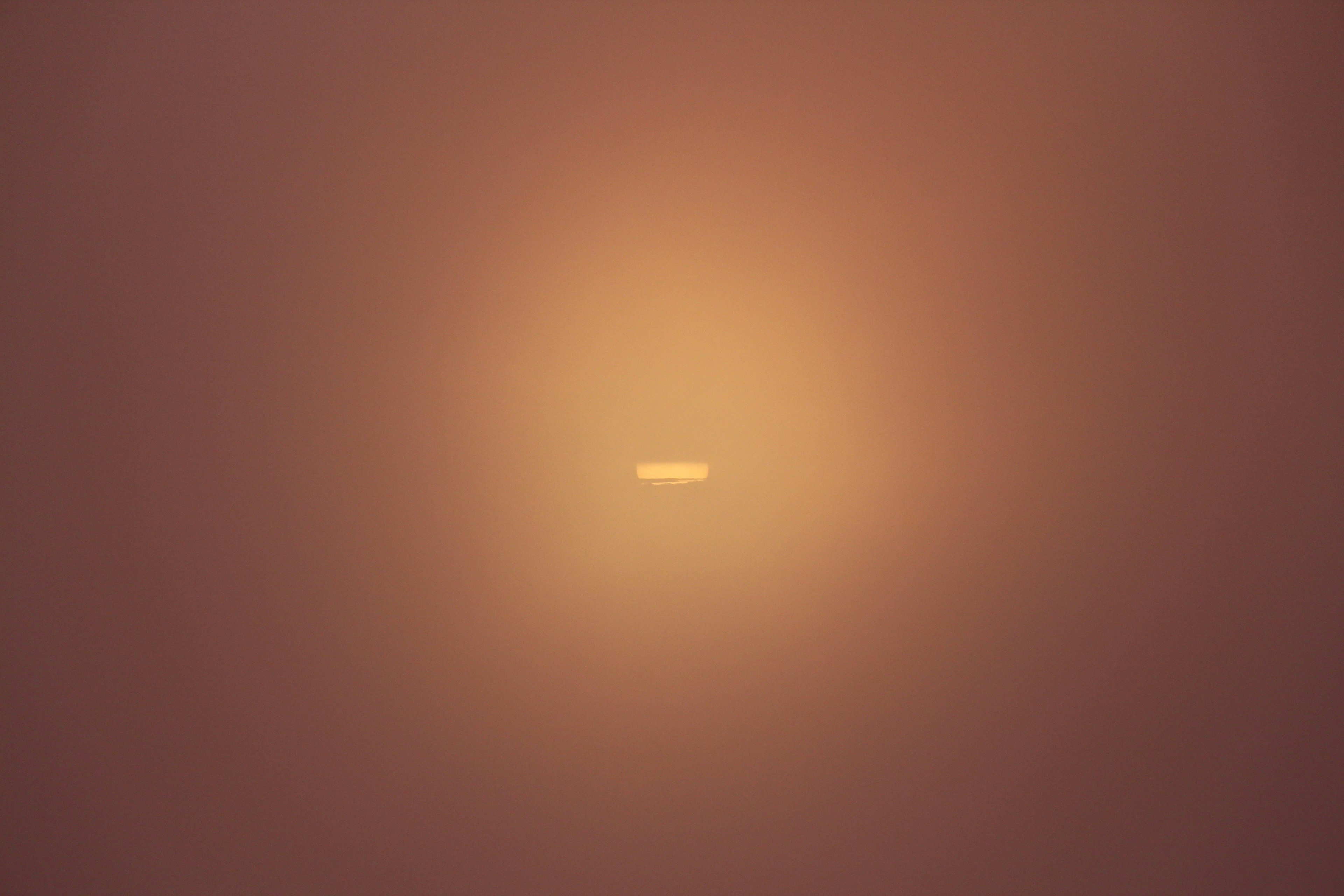 Image featuring a small white dot surrounded by orange light at the center