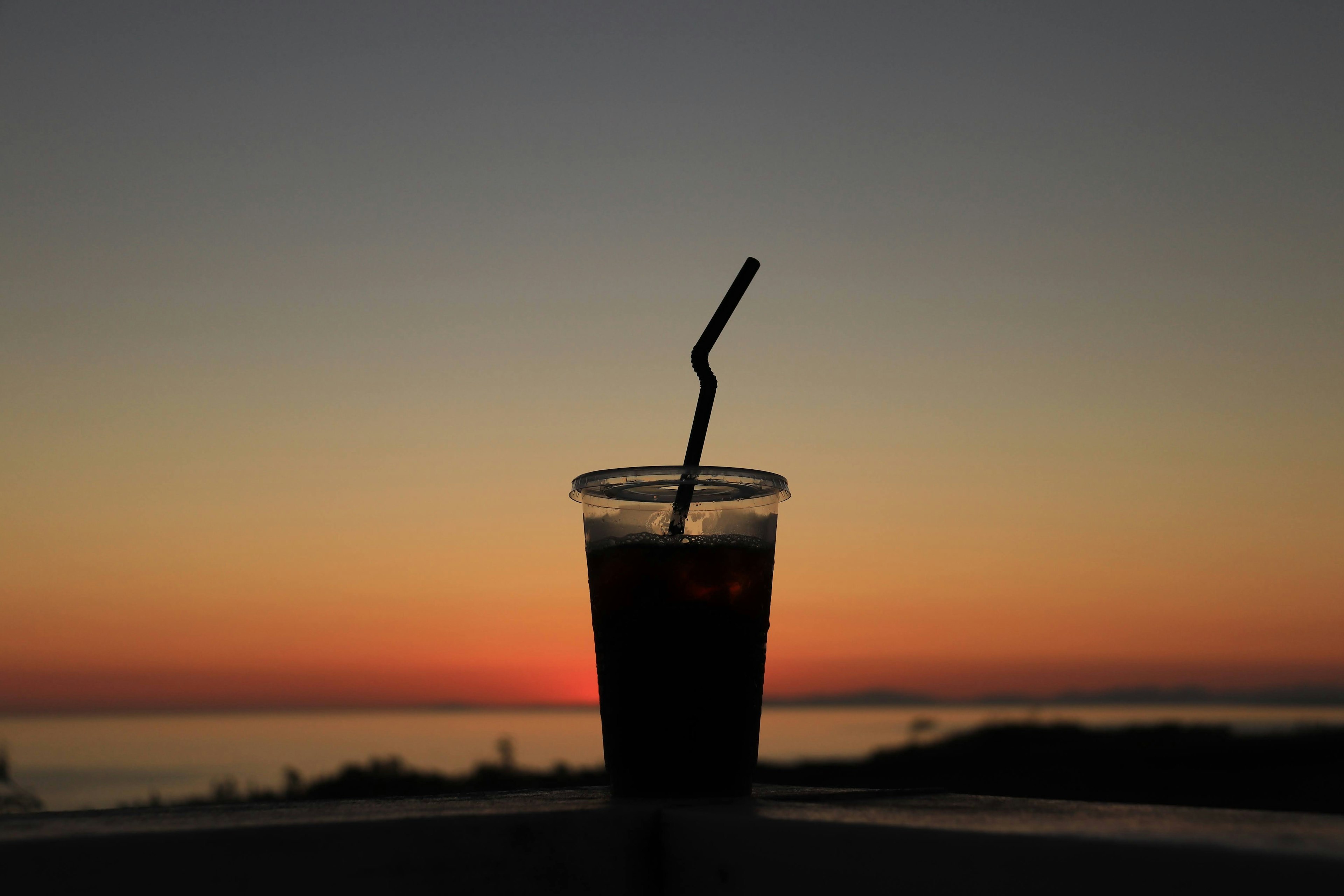 Silhouette of an iced drink against a sunset