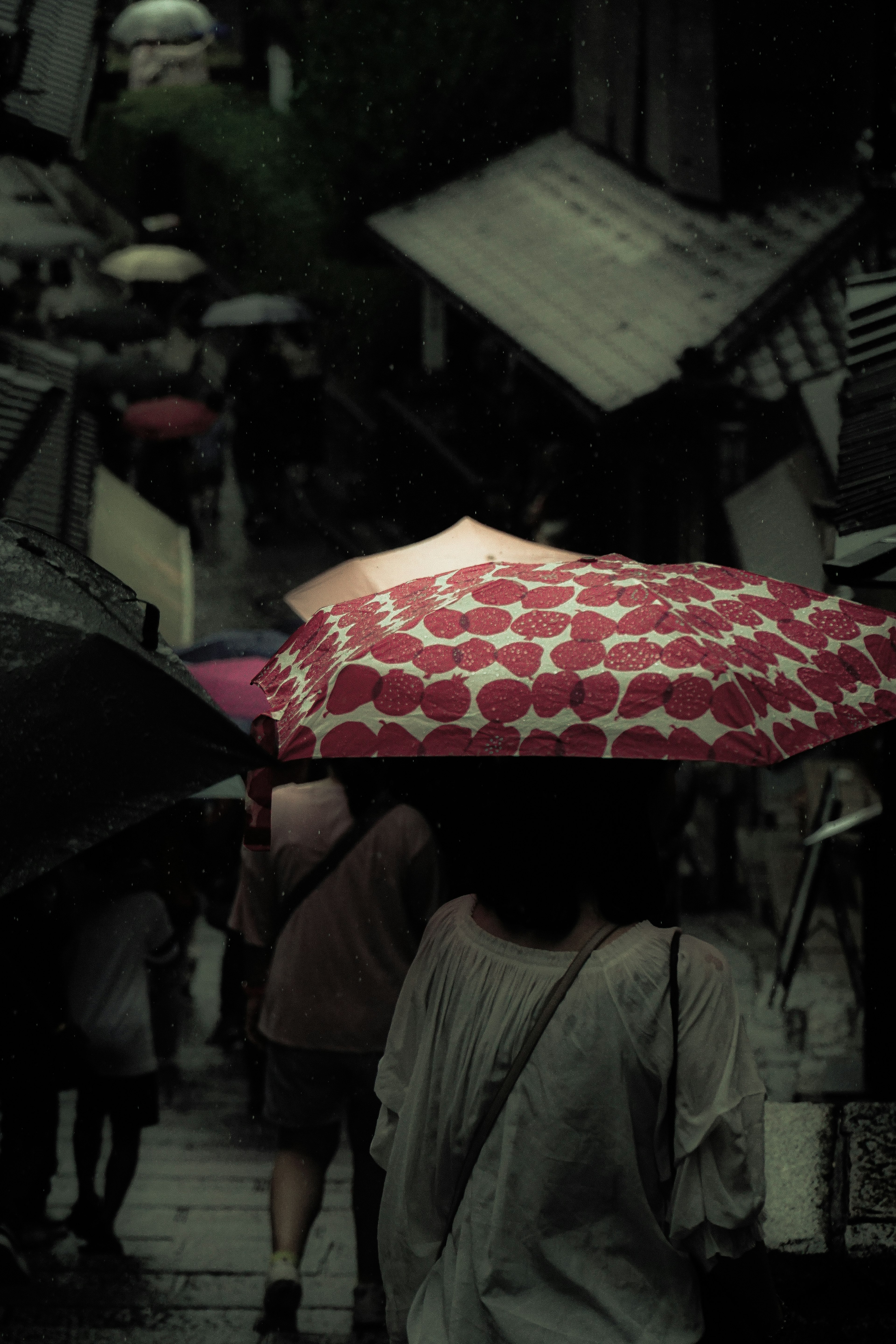 在雨中走路的人群 各種顏色和圖案的雨傘可見