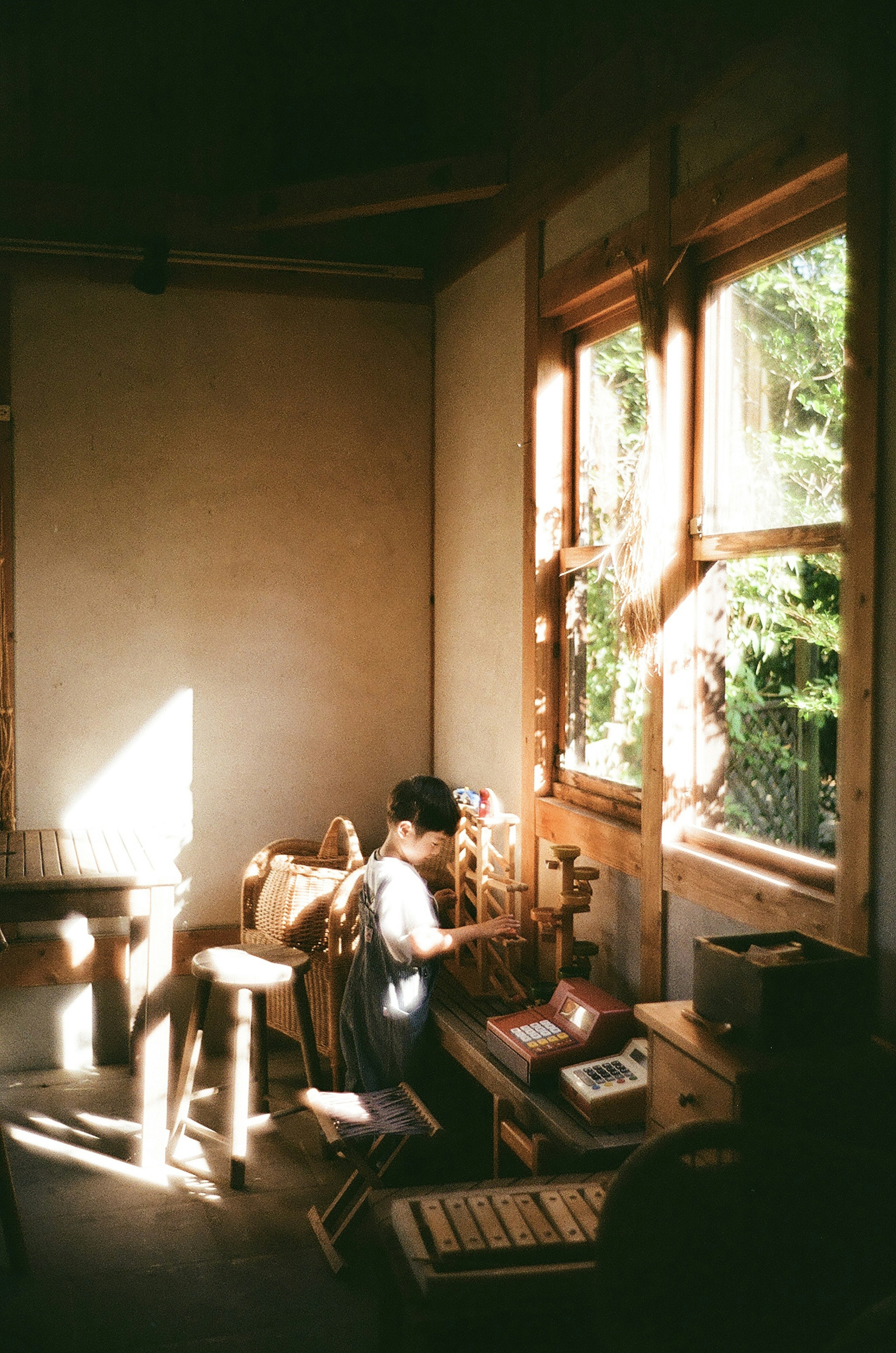 A person working in a workshop with bright windows and wooden furniture