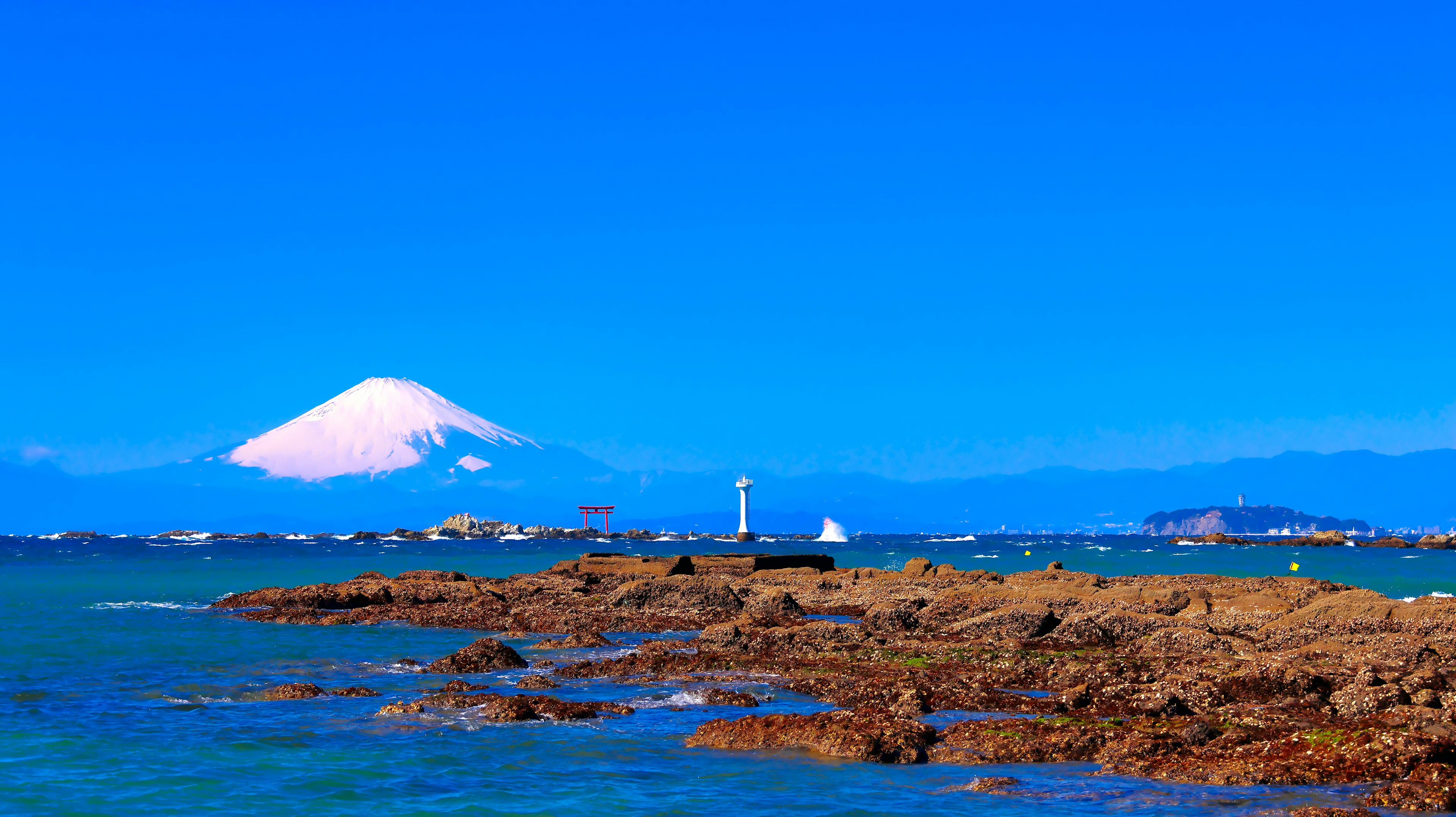 Pemandangan pantai dengan Gunung Fuji di bawah langit biru cerah