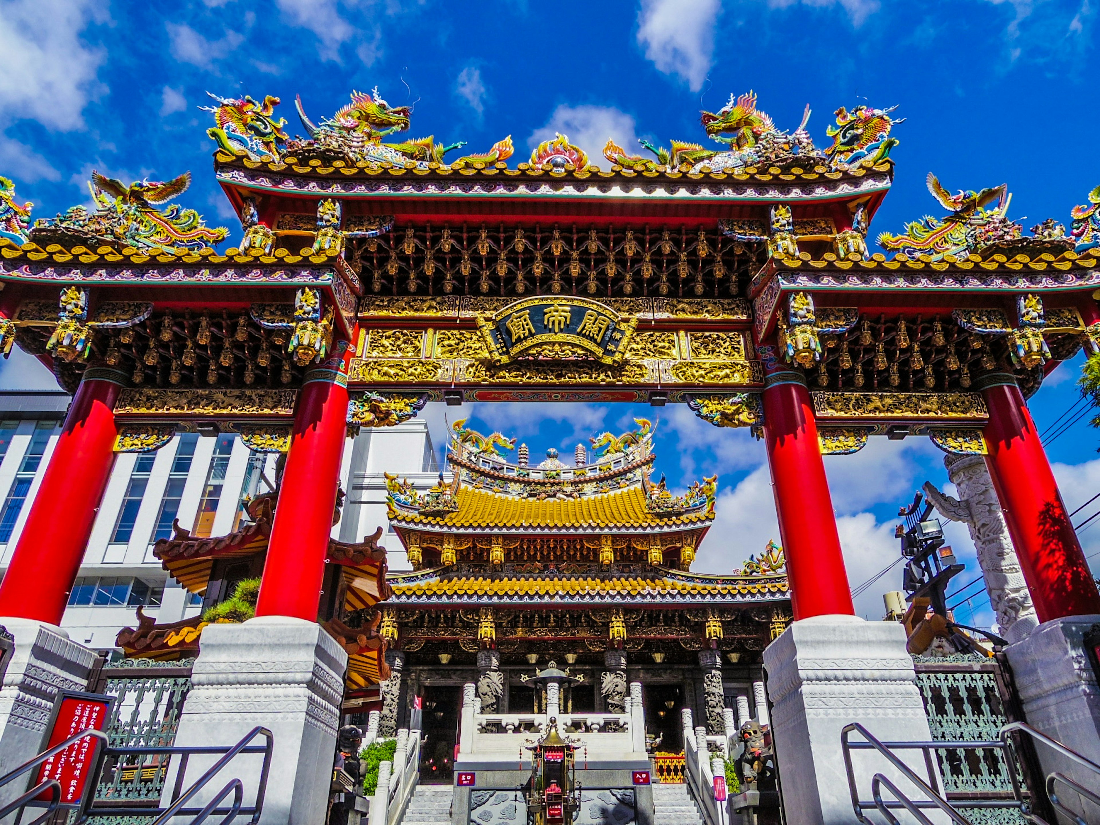 Arcade colorée d'un temple chinois avec des piliers rouges et des décorations dorées