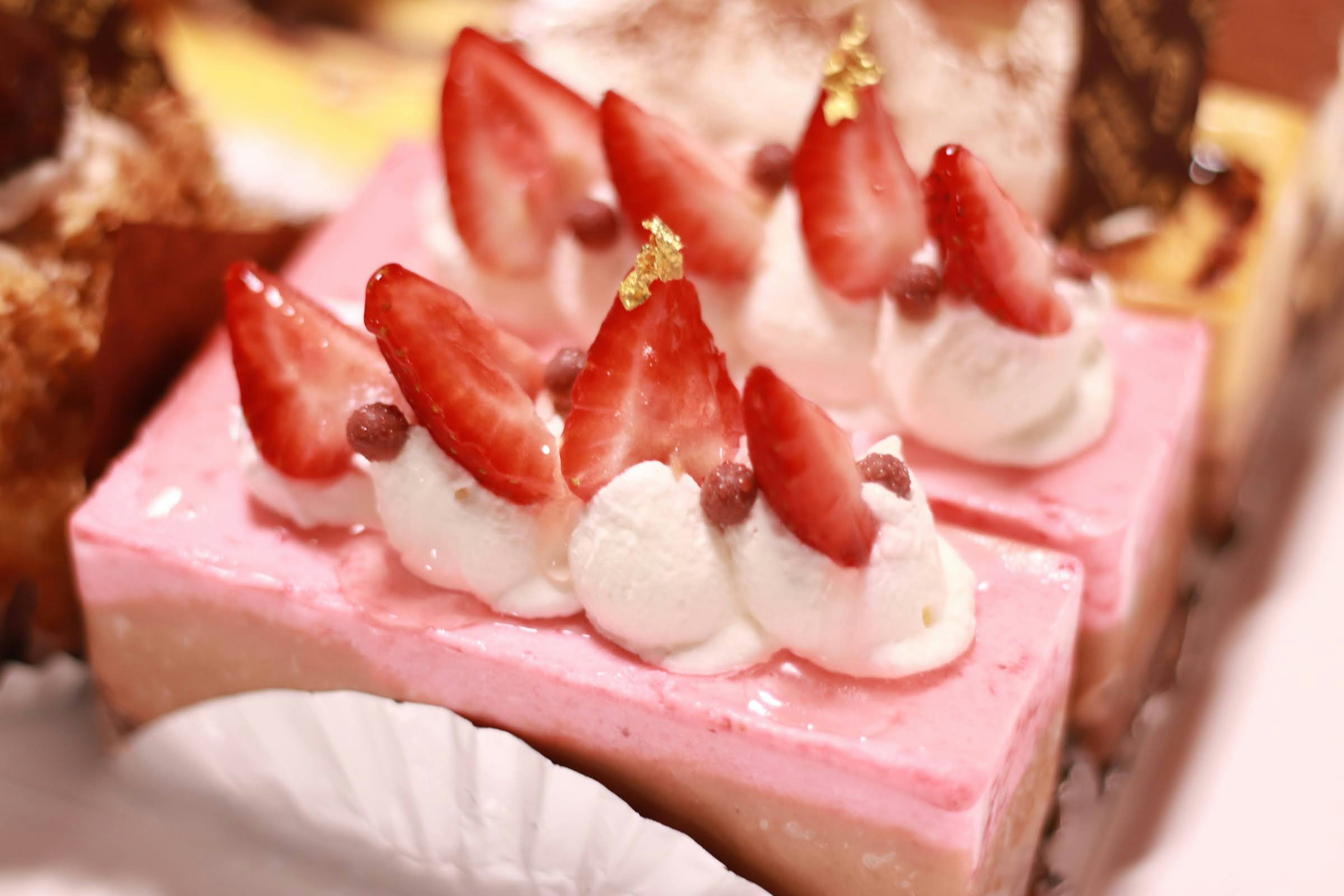 Gâteau rose décoré de fraises et de crème