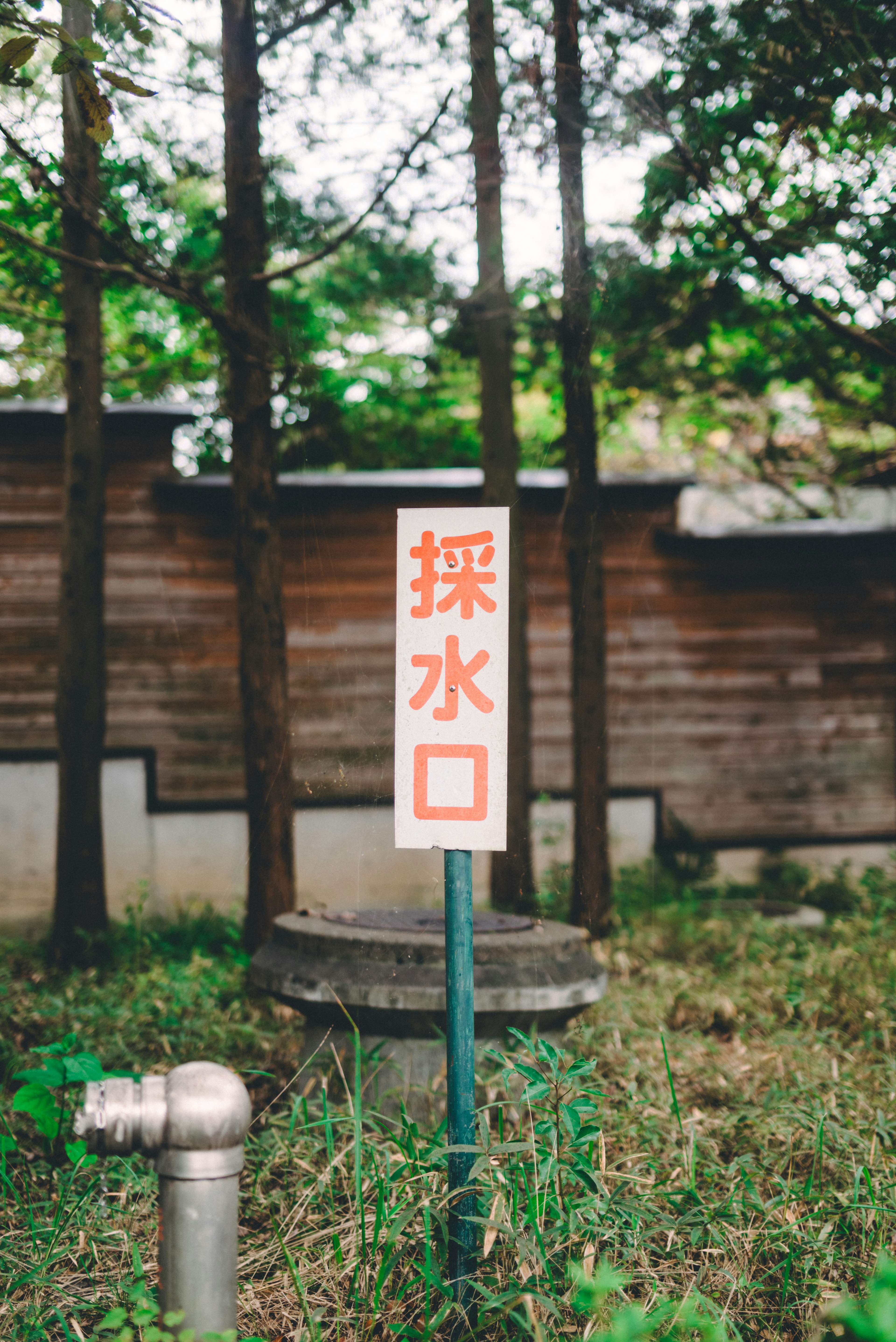 木々に囲まれた水の採取口の標識