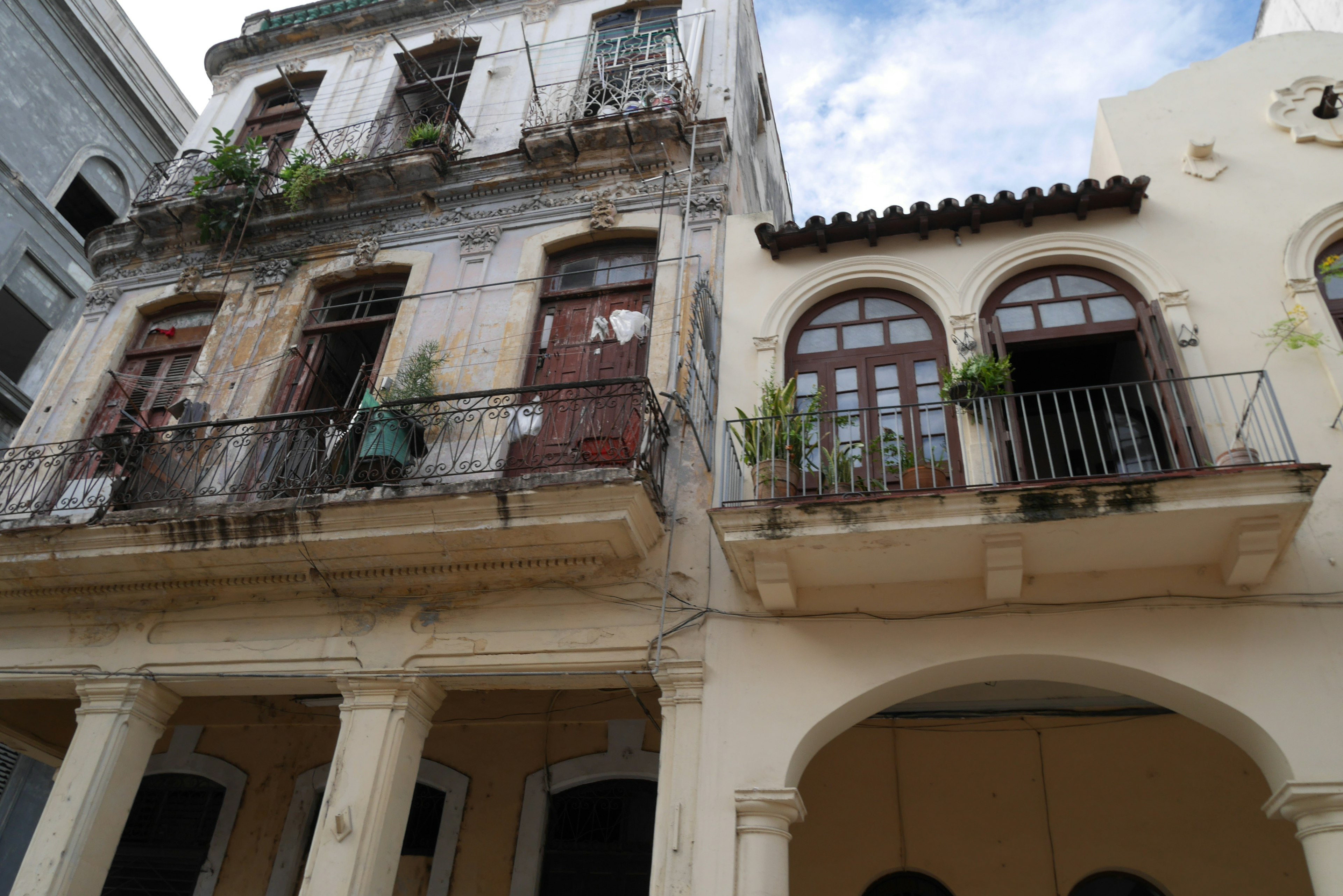 Facade of old buildings with balconies adorned with plants