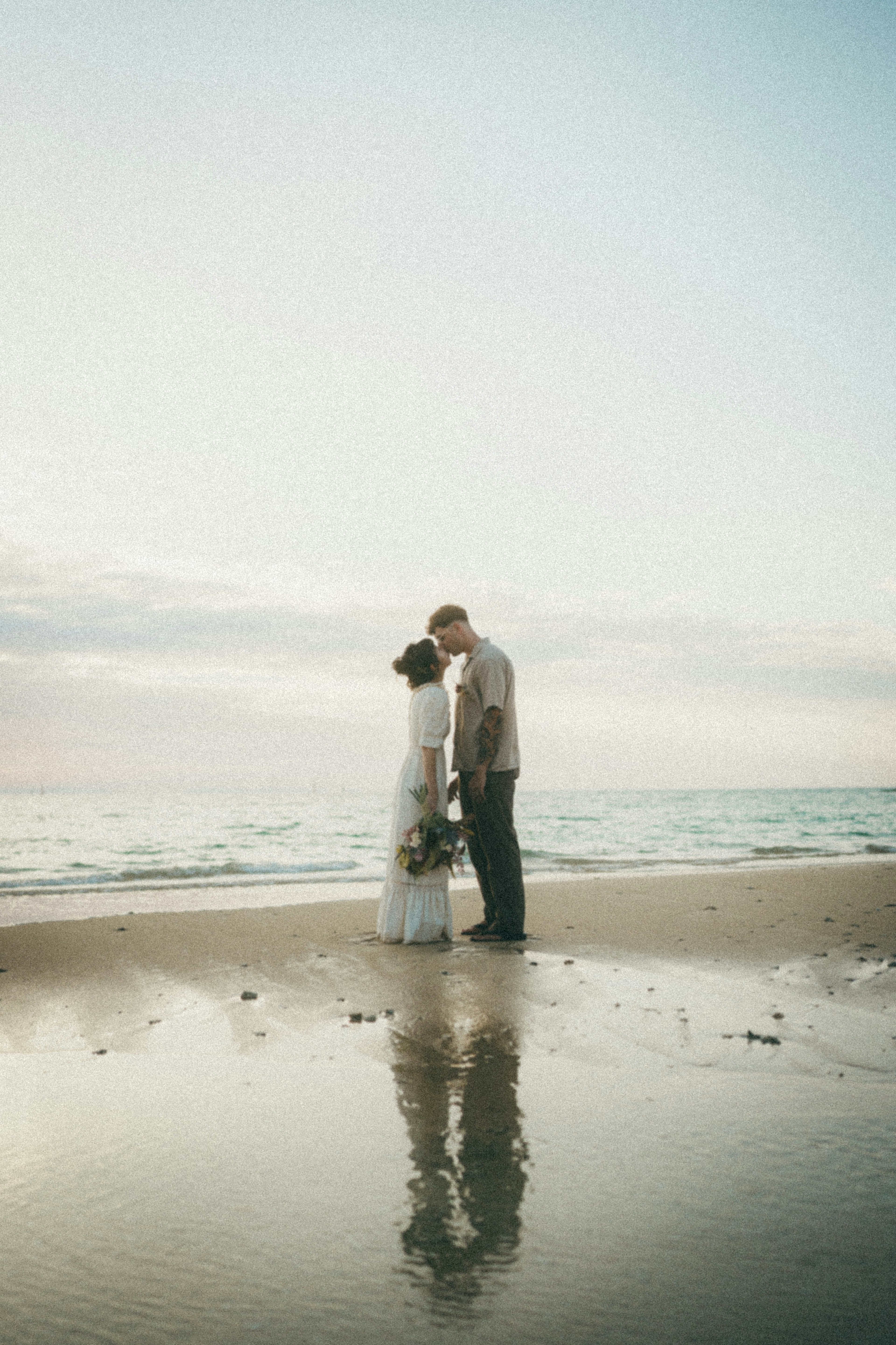 Silueta de una pareja de novios besándose en la playa