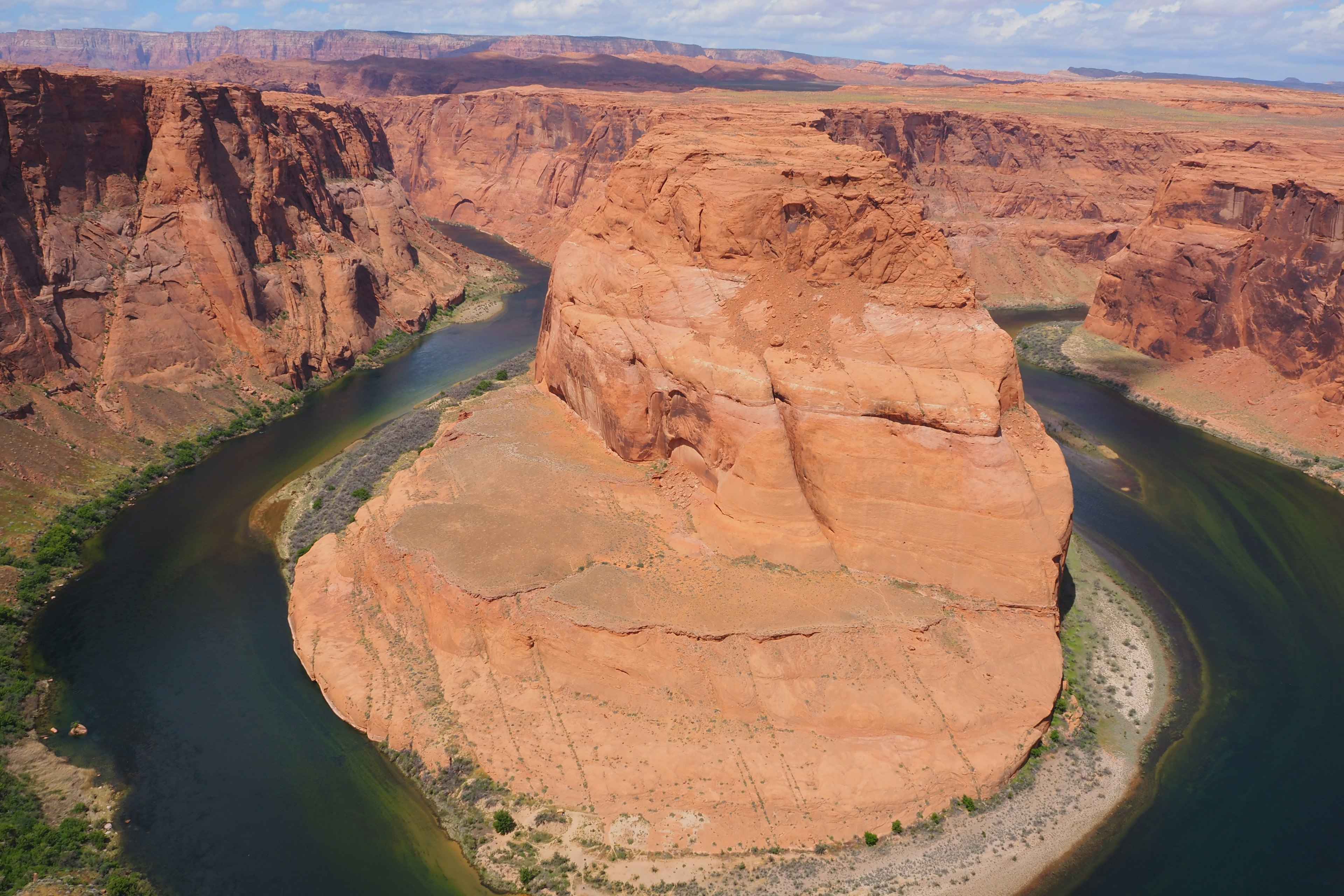 Vista aérea de Horseshoe Bend que muestra formaciones rocosas rojas y un río sinuoso