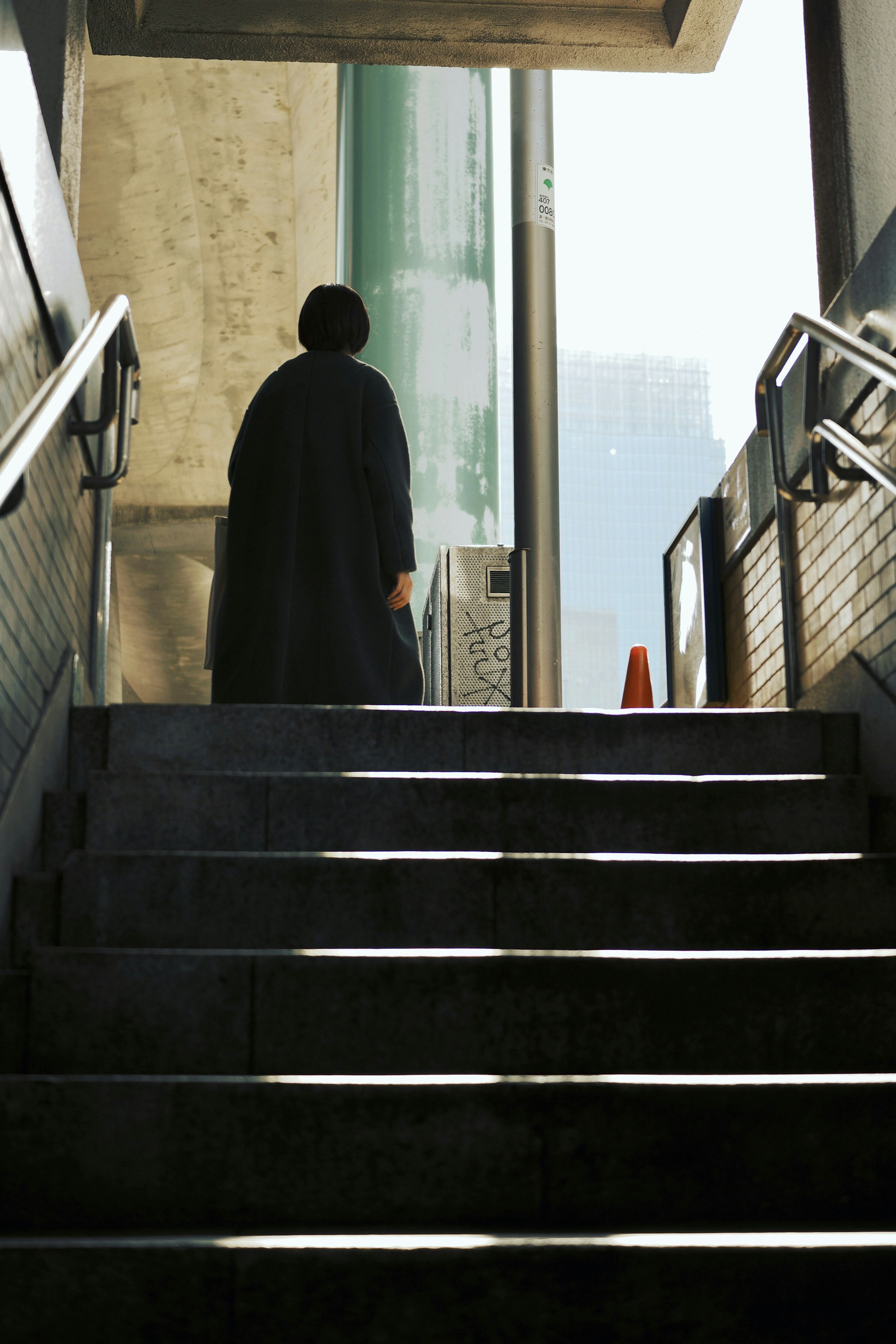 階段を上る人物のシルエットと背景の都市景観