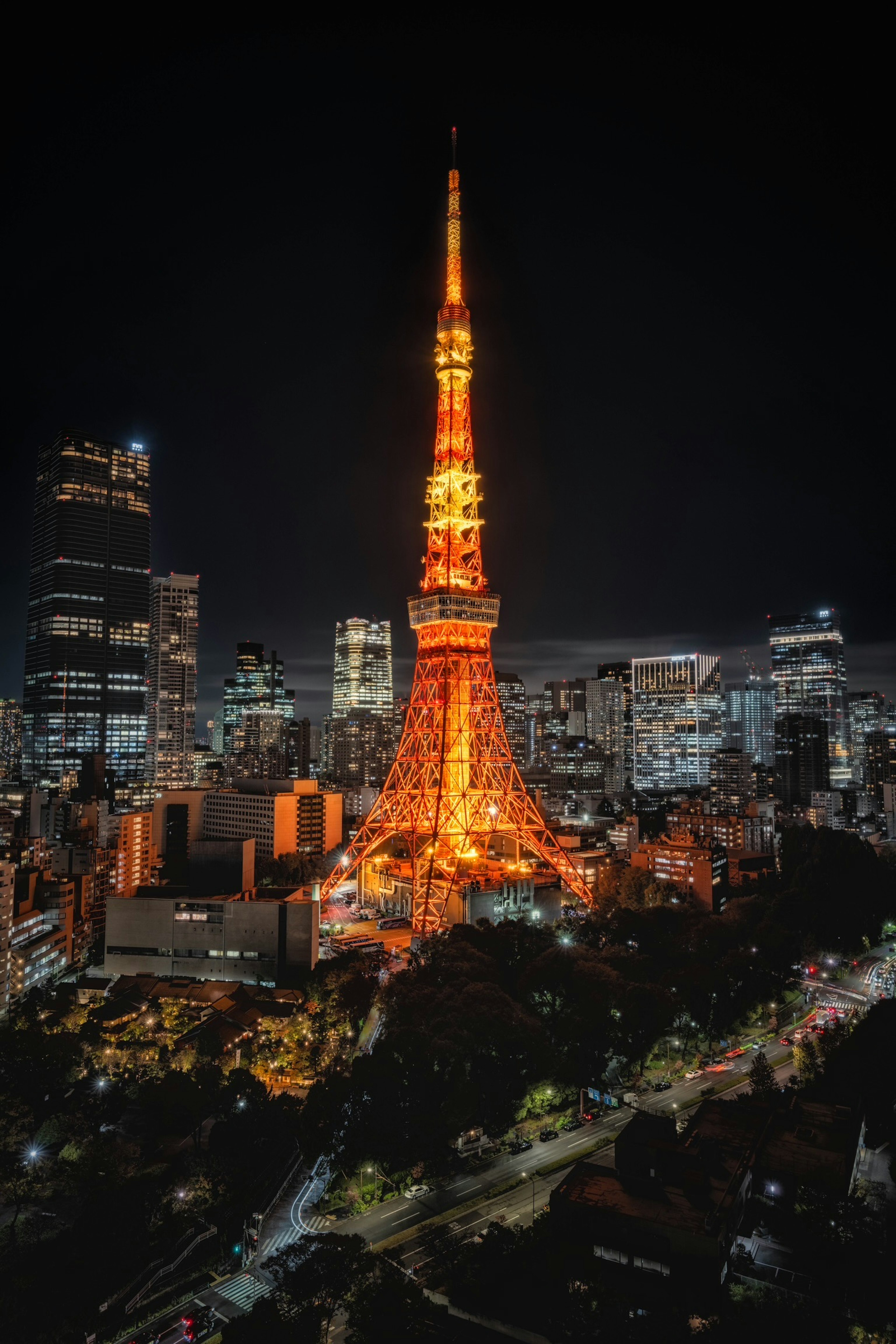 Menara Tokyo yang diterangi oranye di malam hari menampilkan pemandangan kota yang hidup