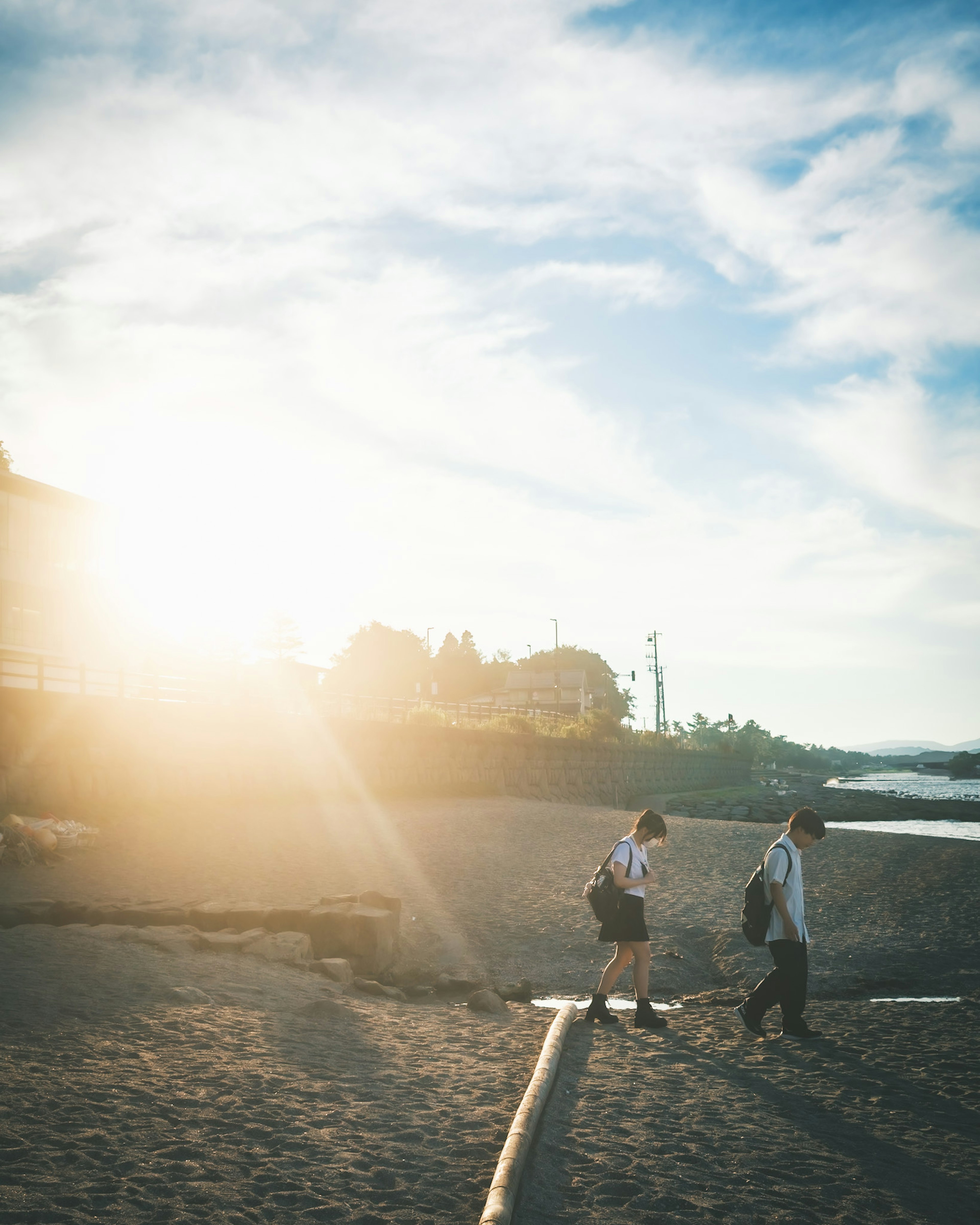 Zwei Personen gehen am Strand bei Sonnenuntergang