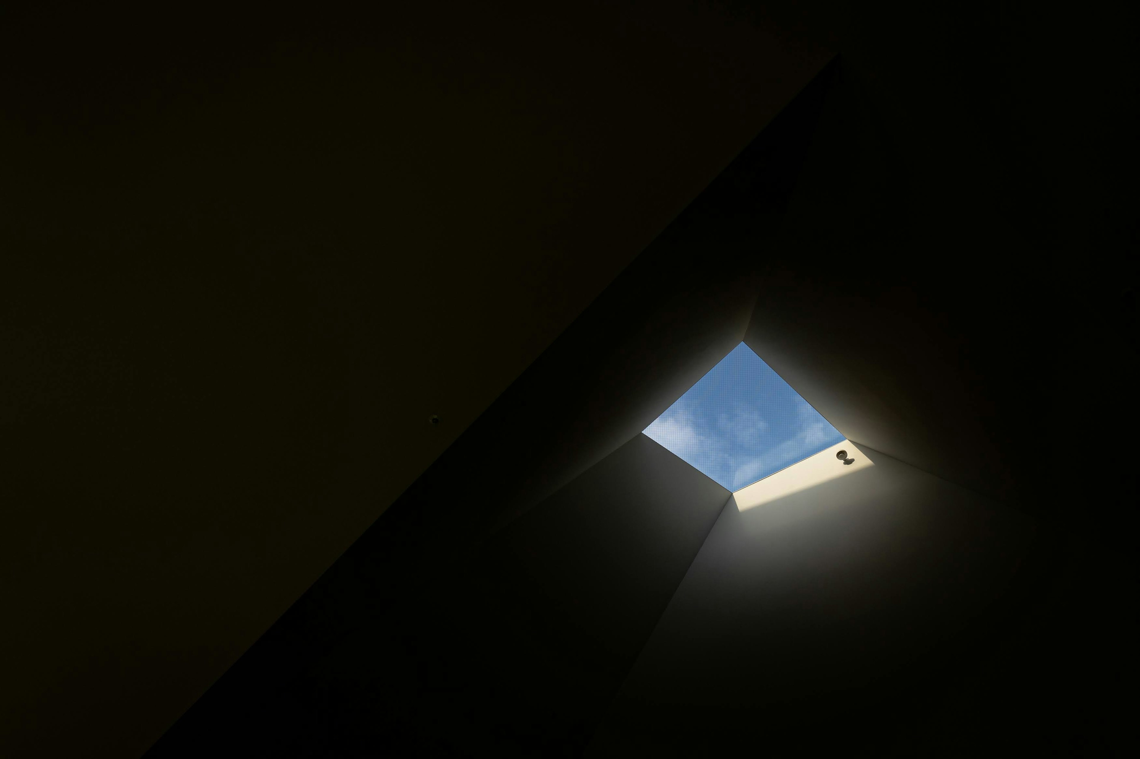 Skylight revealing blue sky in a dark space