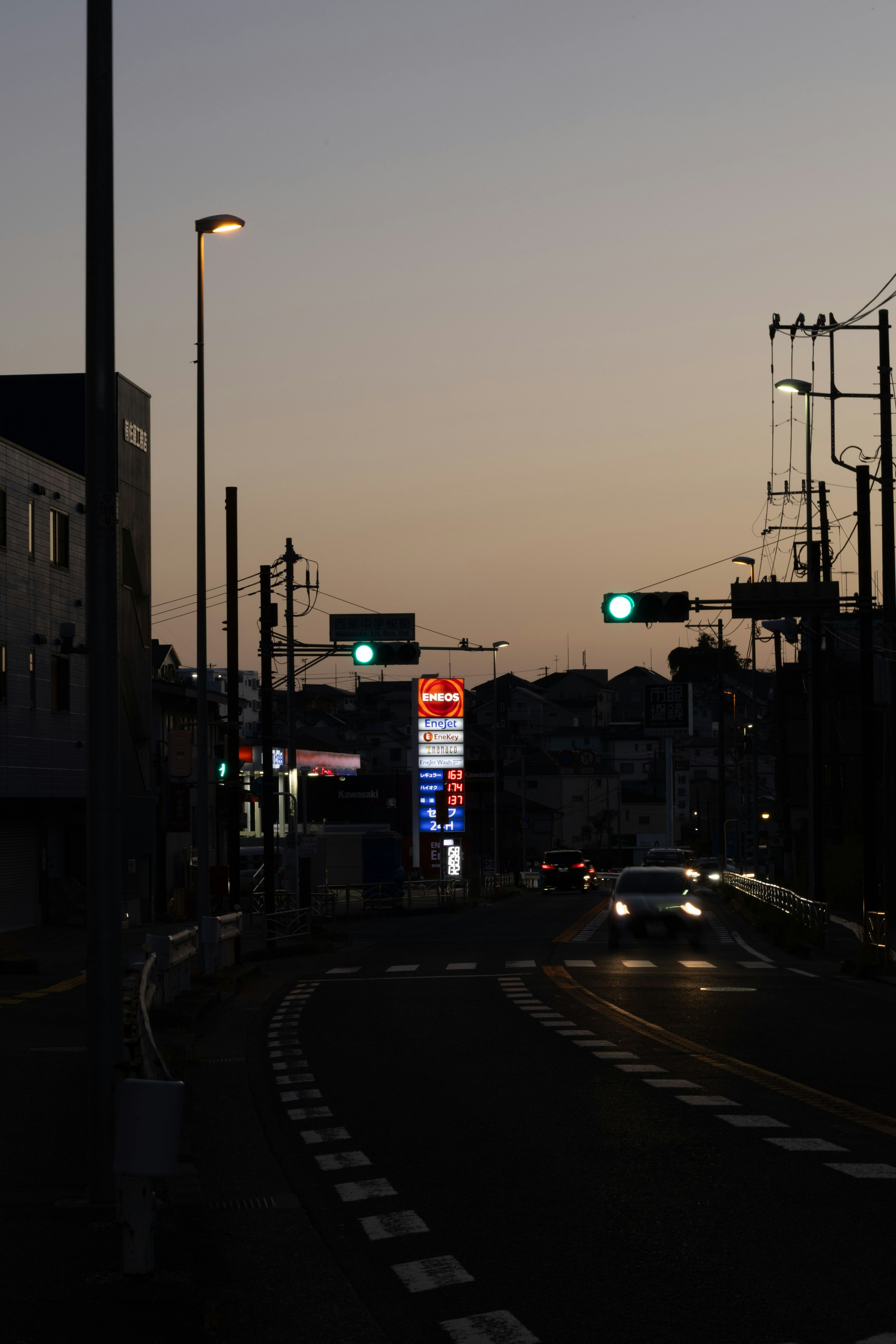 夕暮れ時の街道にある信号機と街灯の光