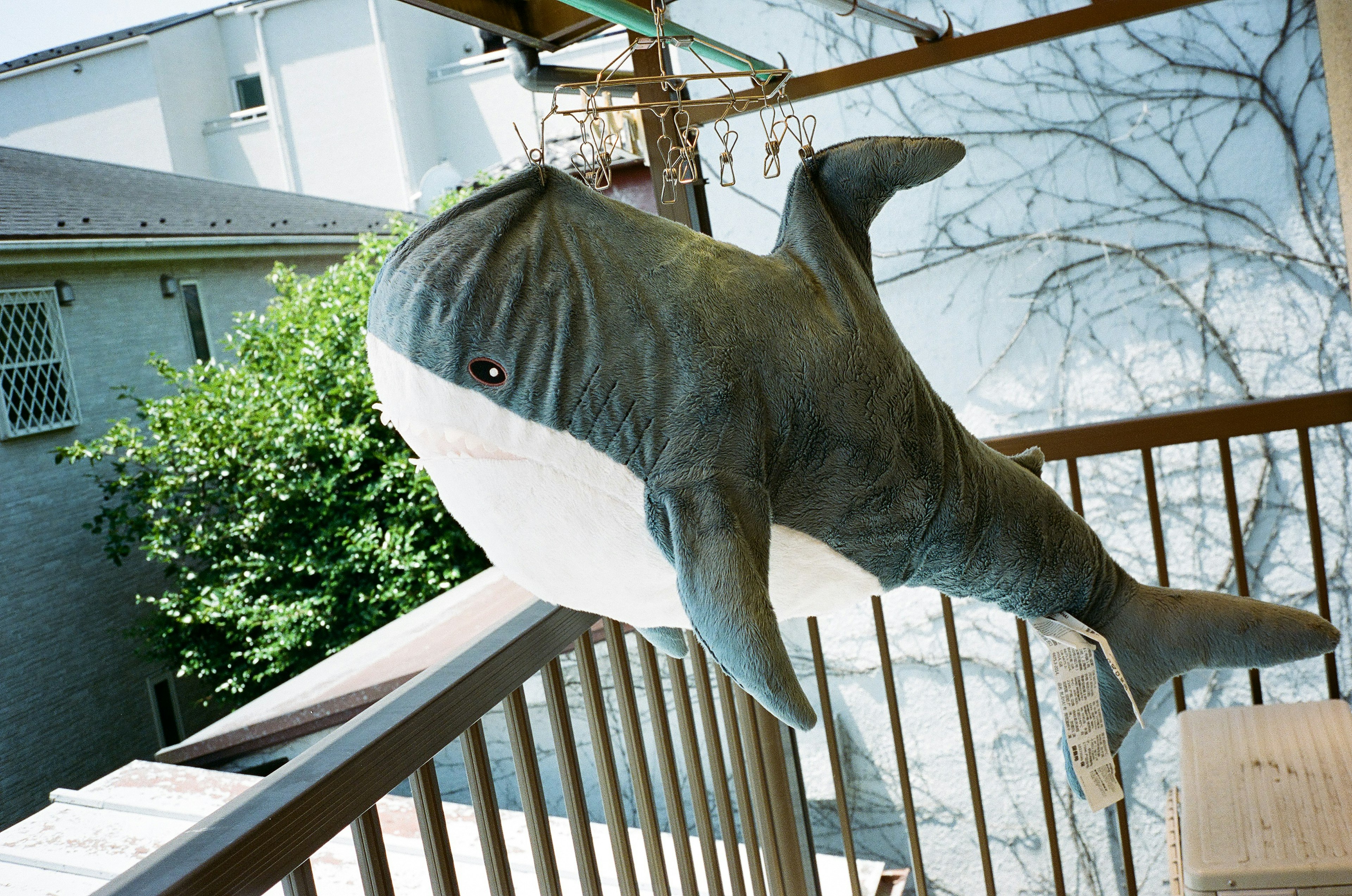 Un jouet en peluche en forme de baleine sur un balcon avec des couleurs vives et un design unique