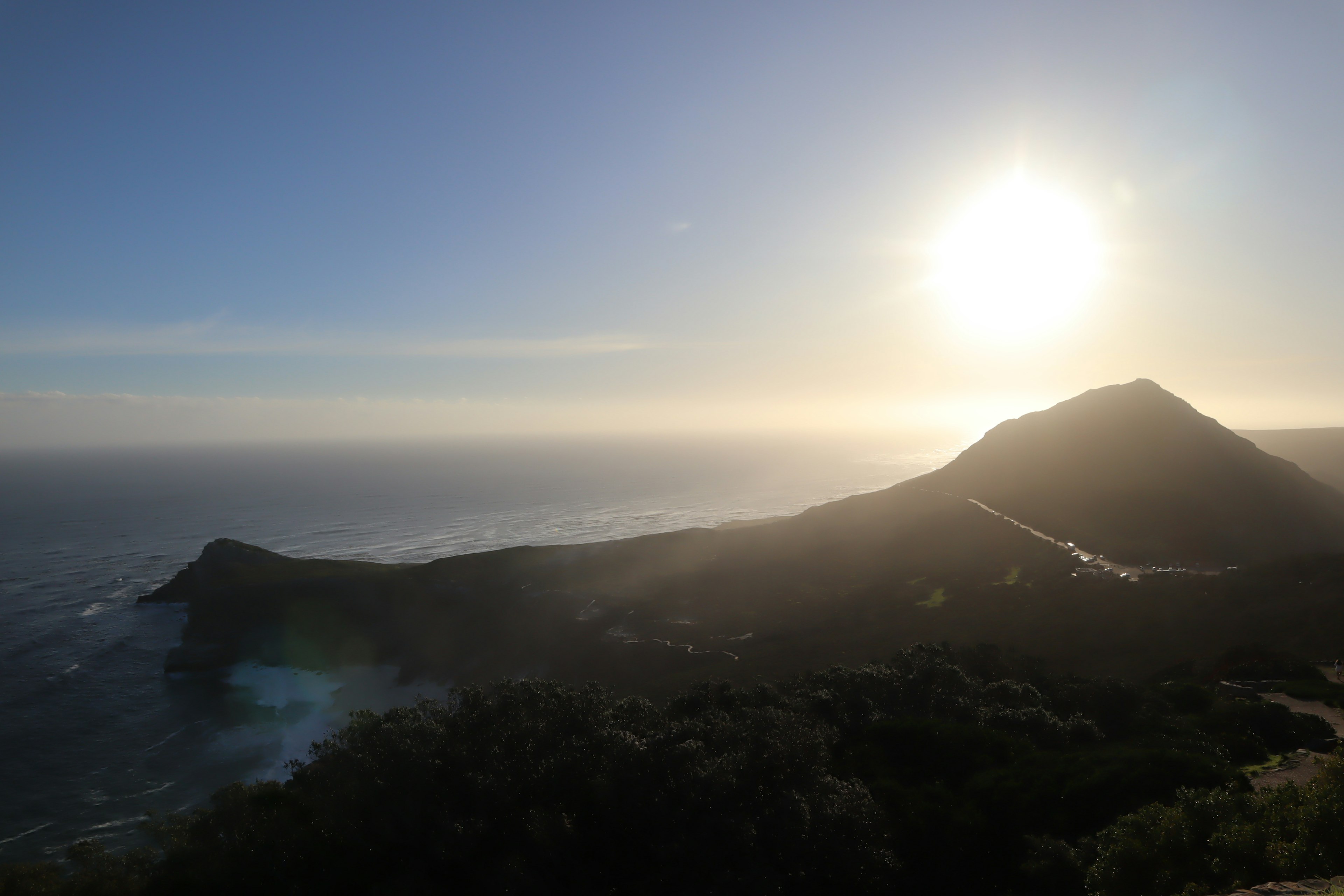 Vista ampia dell'oceano e delle montagne con il sole che tramonta