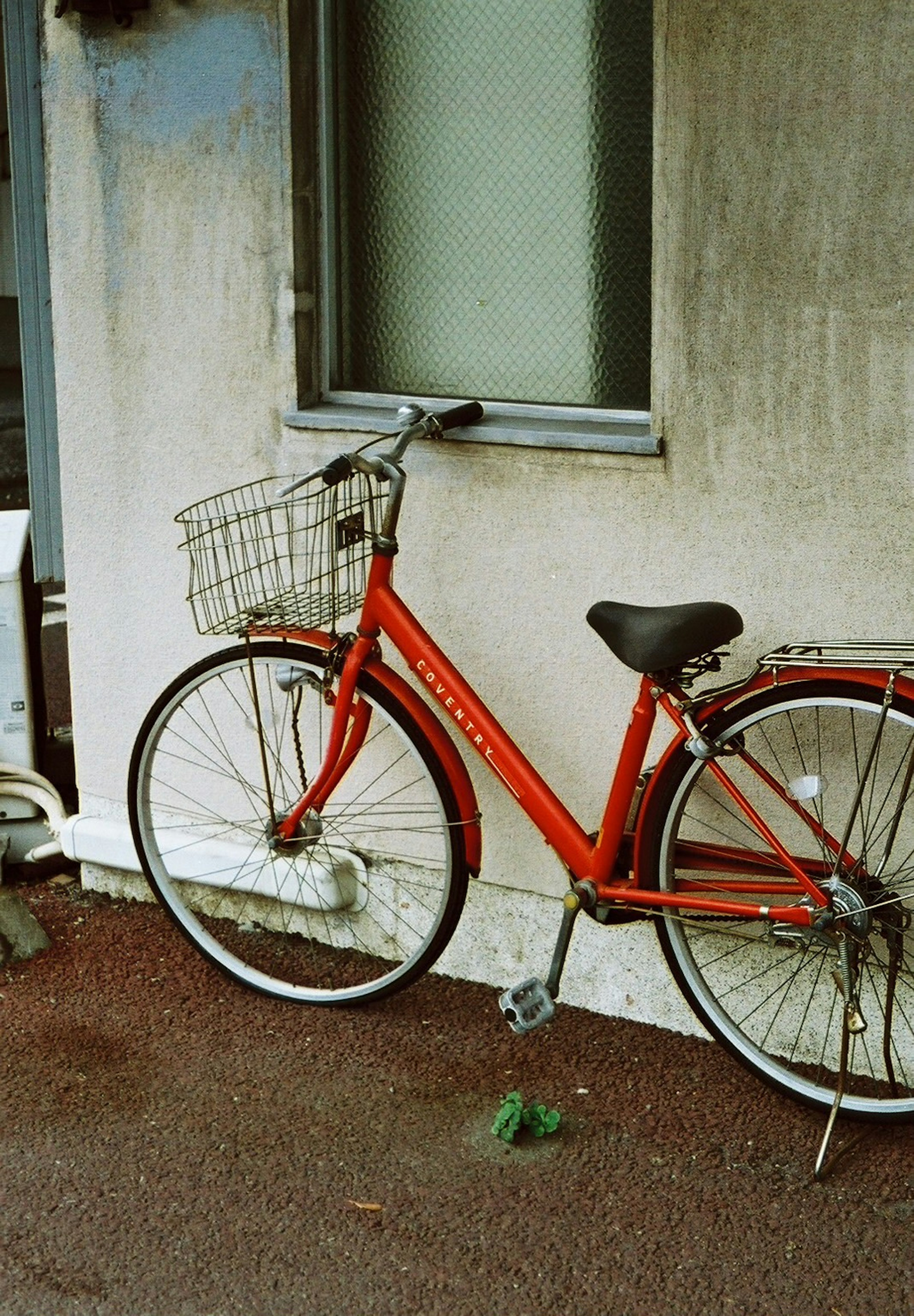 赤い自転車が壁の近くに置かれている