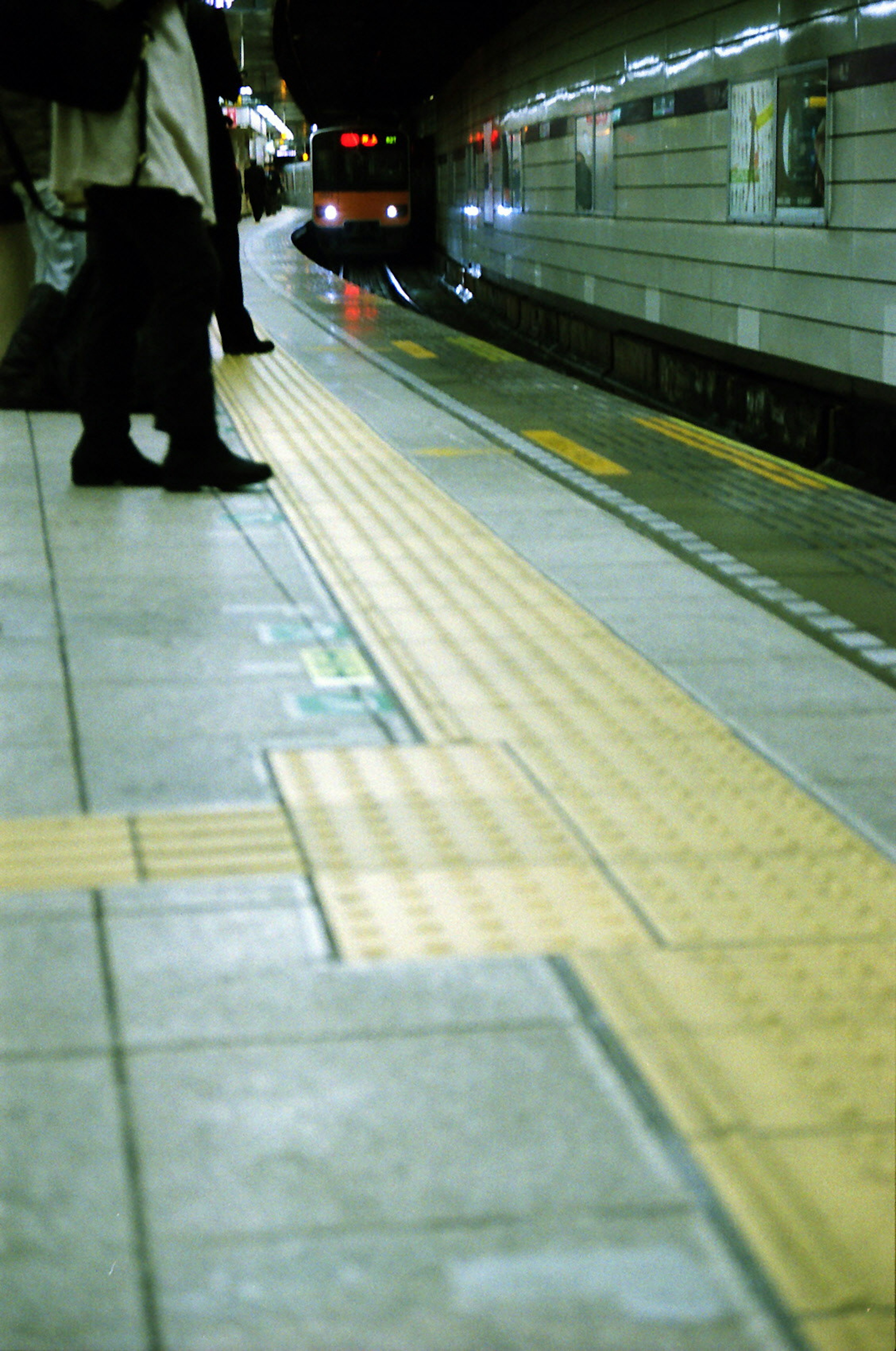 People standing on a subway platform with yellow safety lines