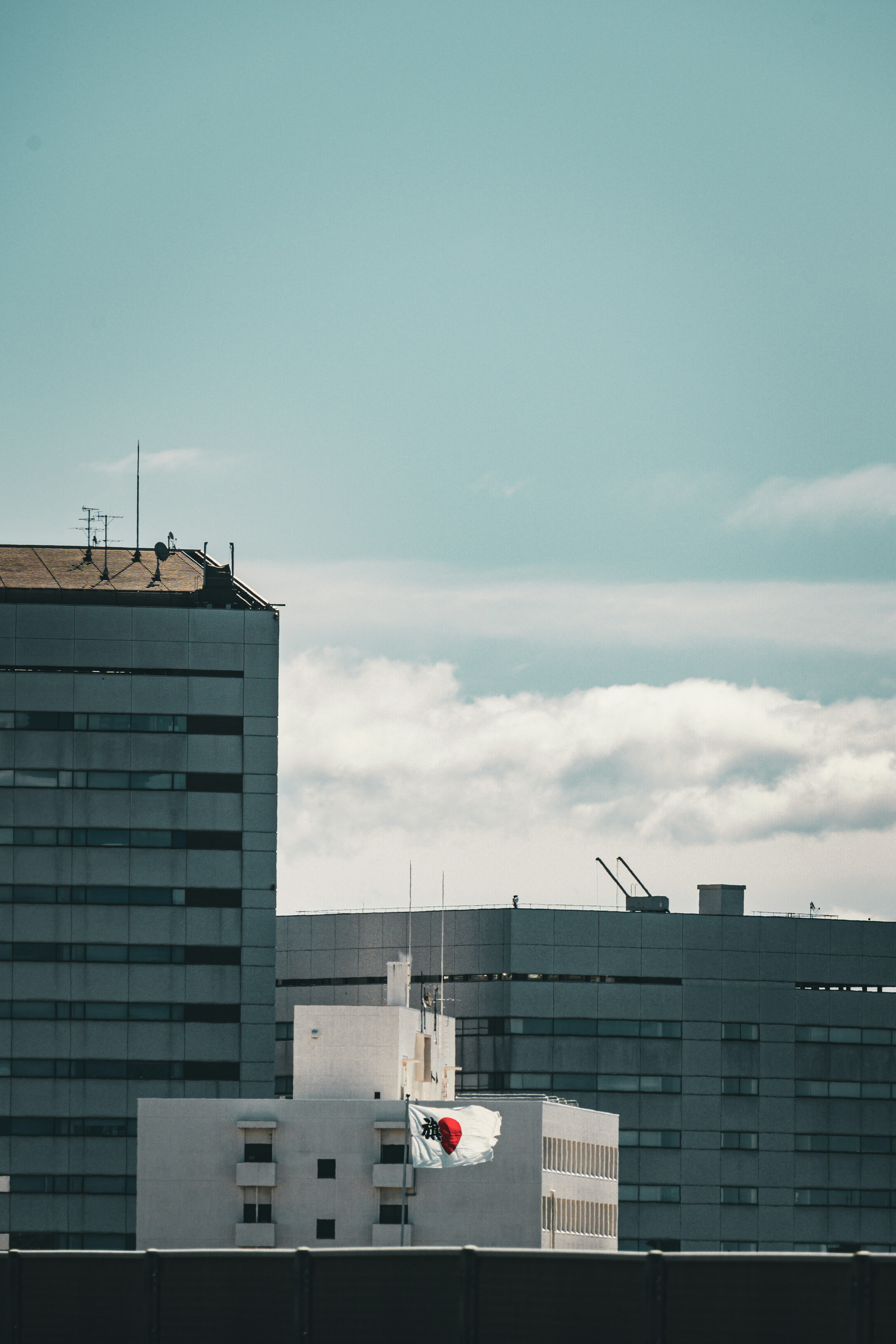 Cityscape featuring tall buildings under a blue sky with clouds