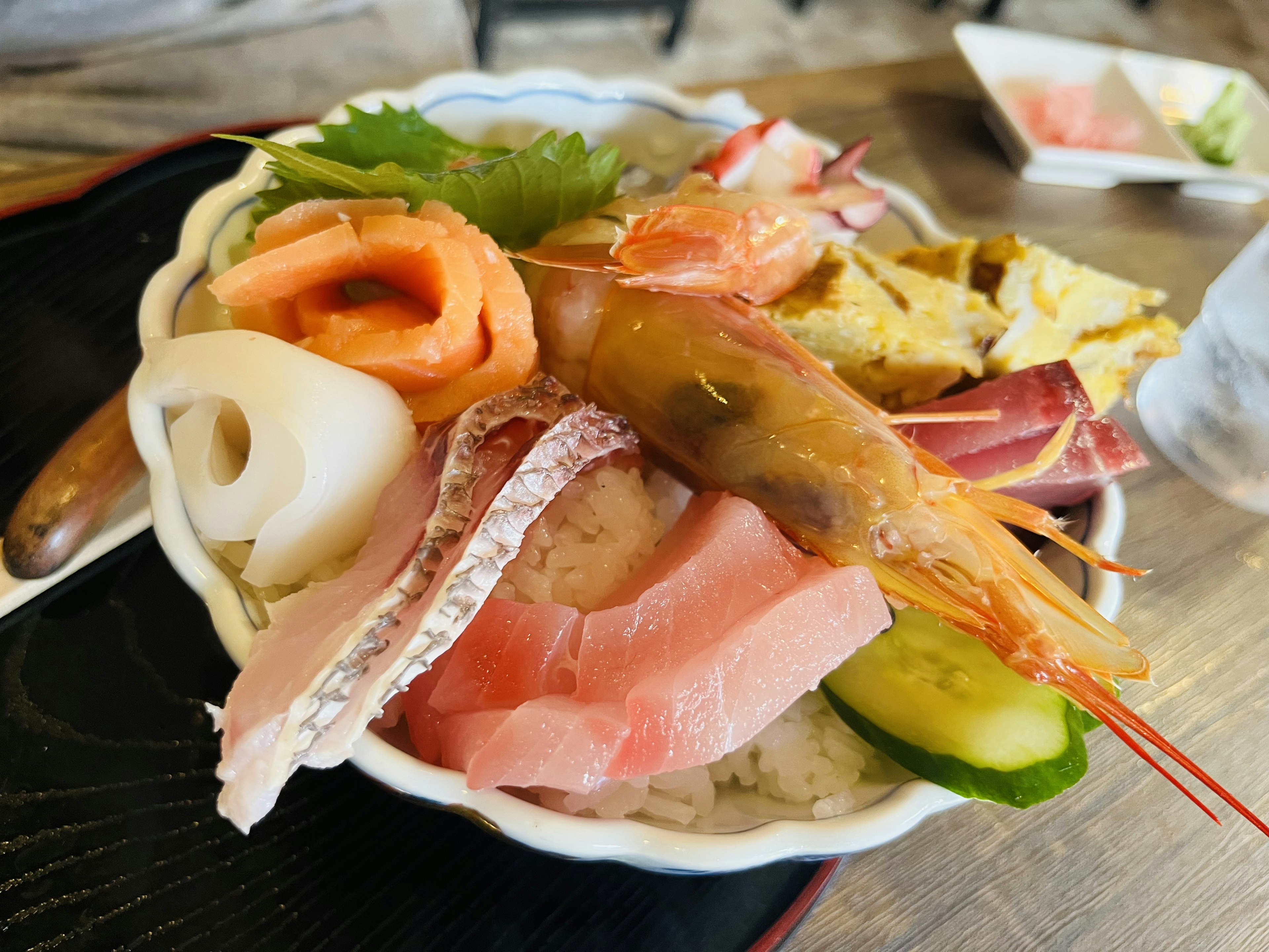 海鮮丼の盛り付け、新鮮な刺身、エビ、サーモン、野菜