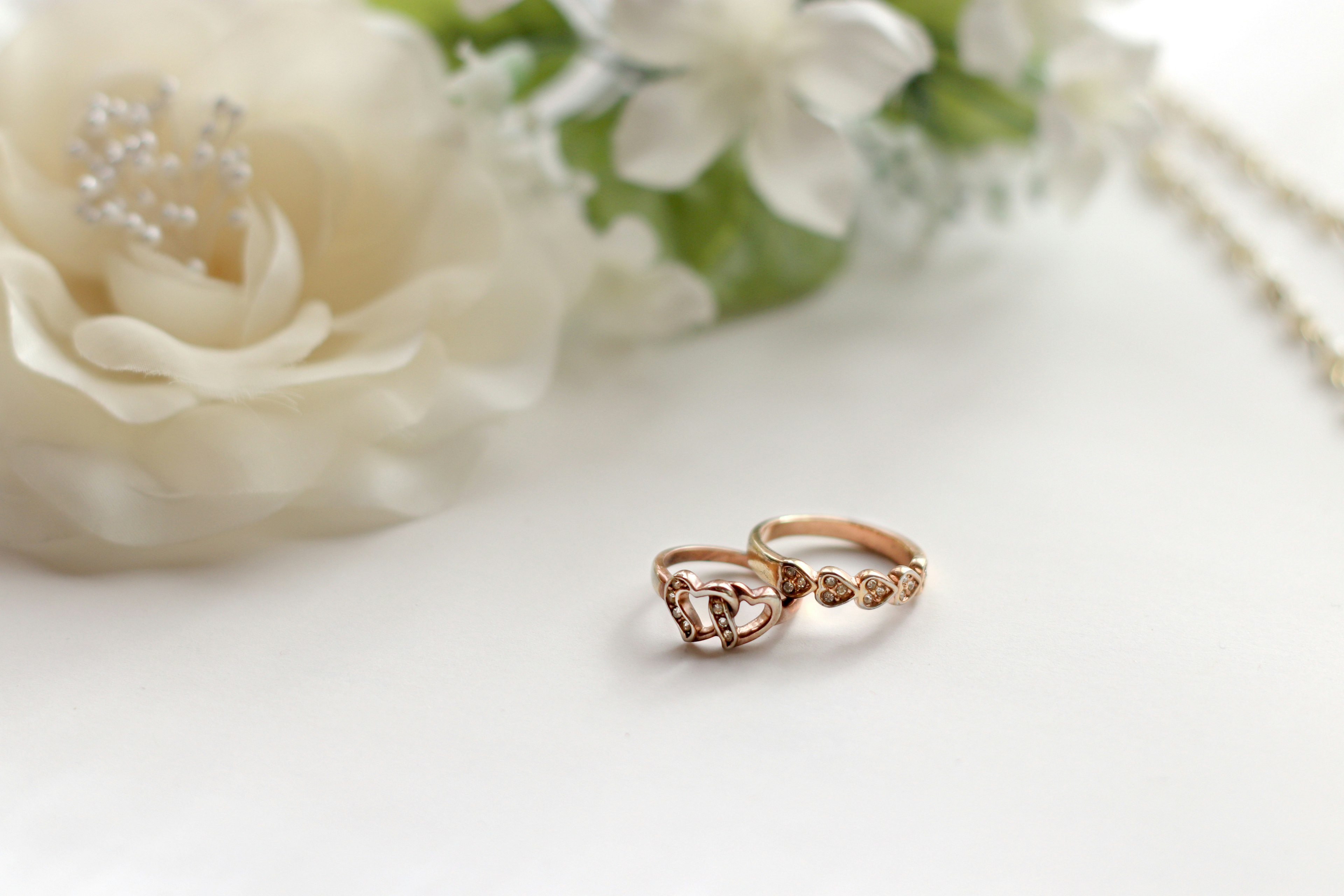 A beautiful rose gold ring placed near a white flower