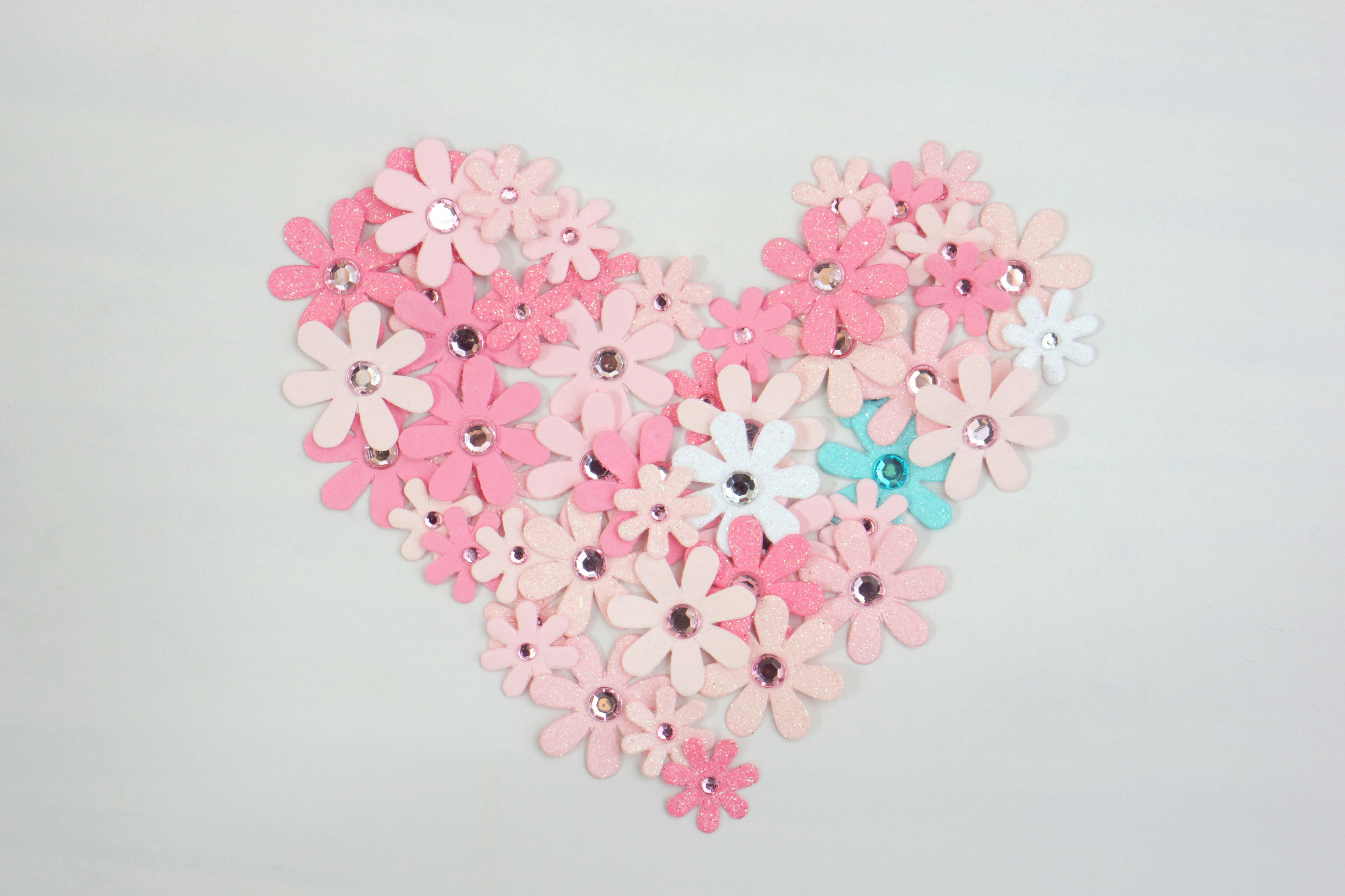 Heart-shaped arrangement of flowers in soft pink and white