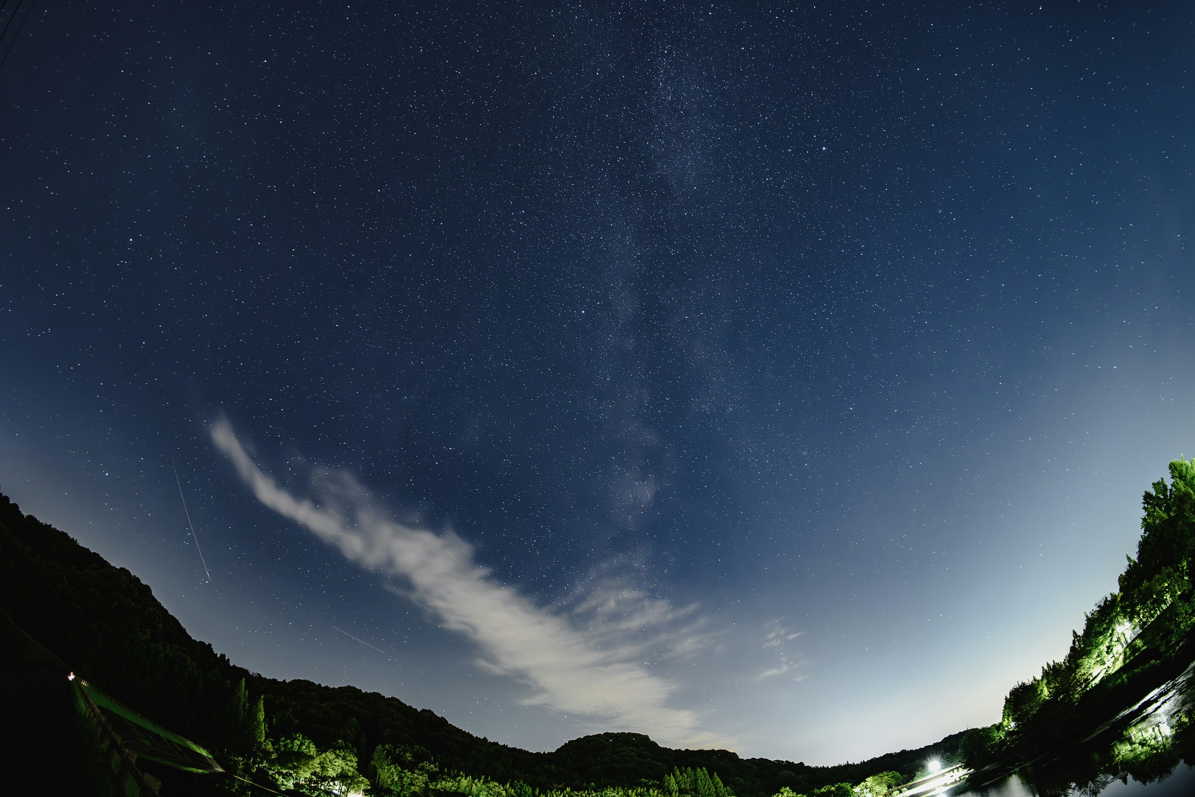 Paisaje de montañas y agua bajo un cielo estrellado