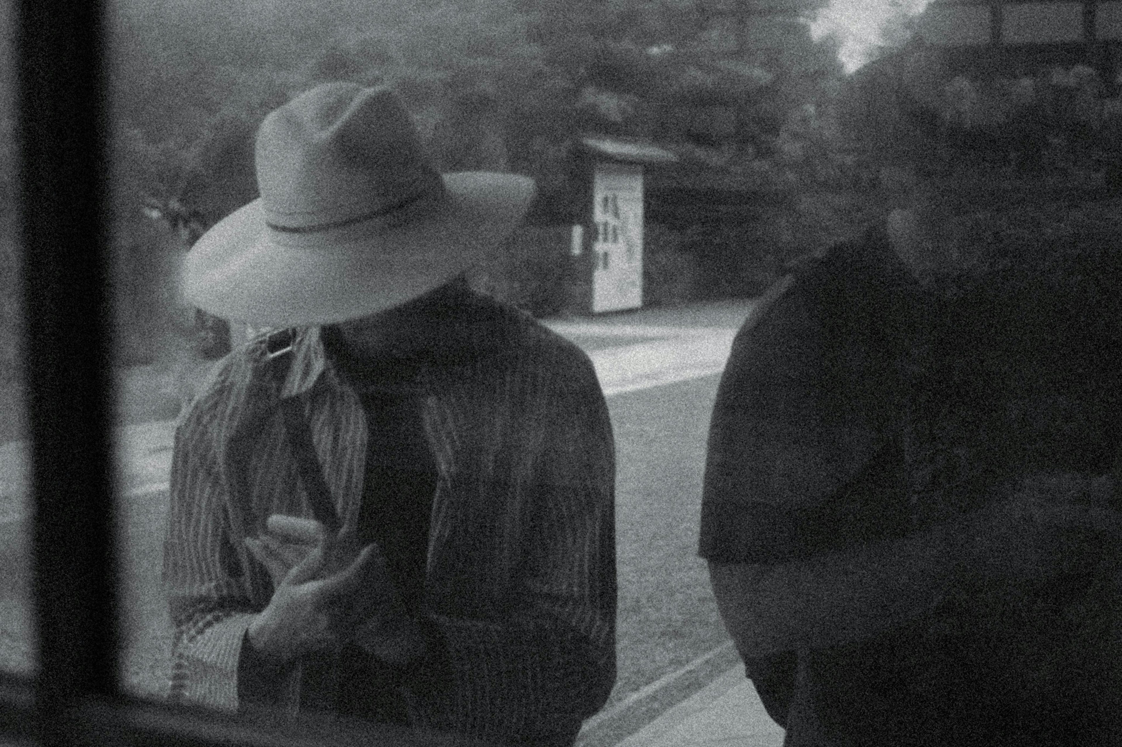 Dos hombres mirando sus smartphones en una foto en blanco y negro