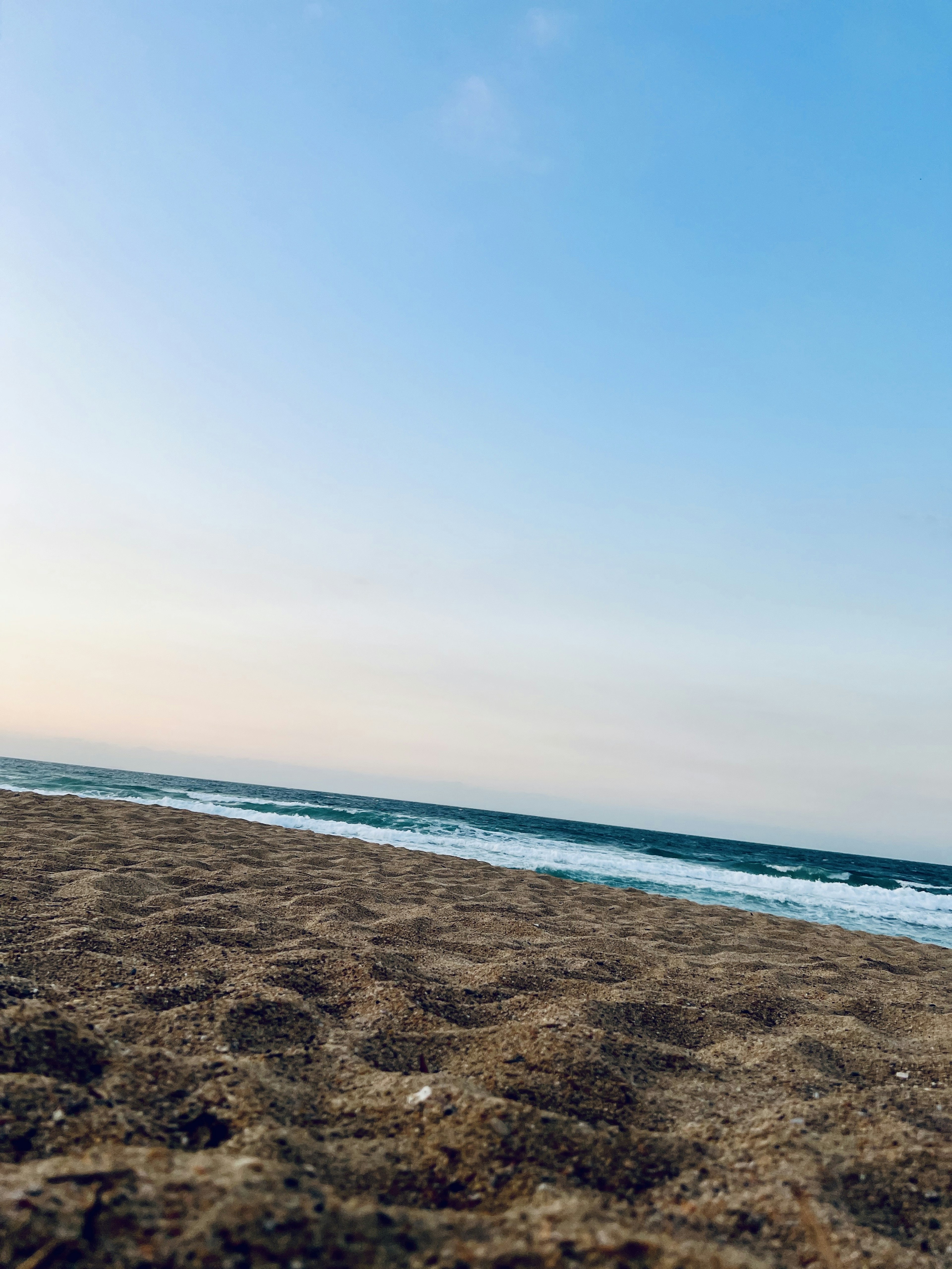 Scène de plage avec du sable et des vagues de l'océan sous un ciel bleu