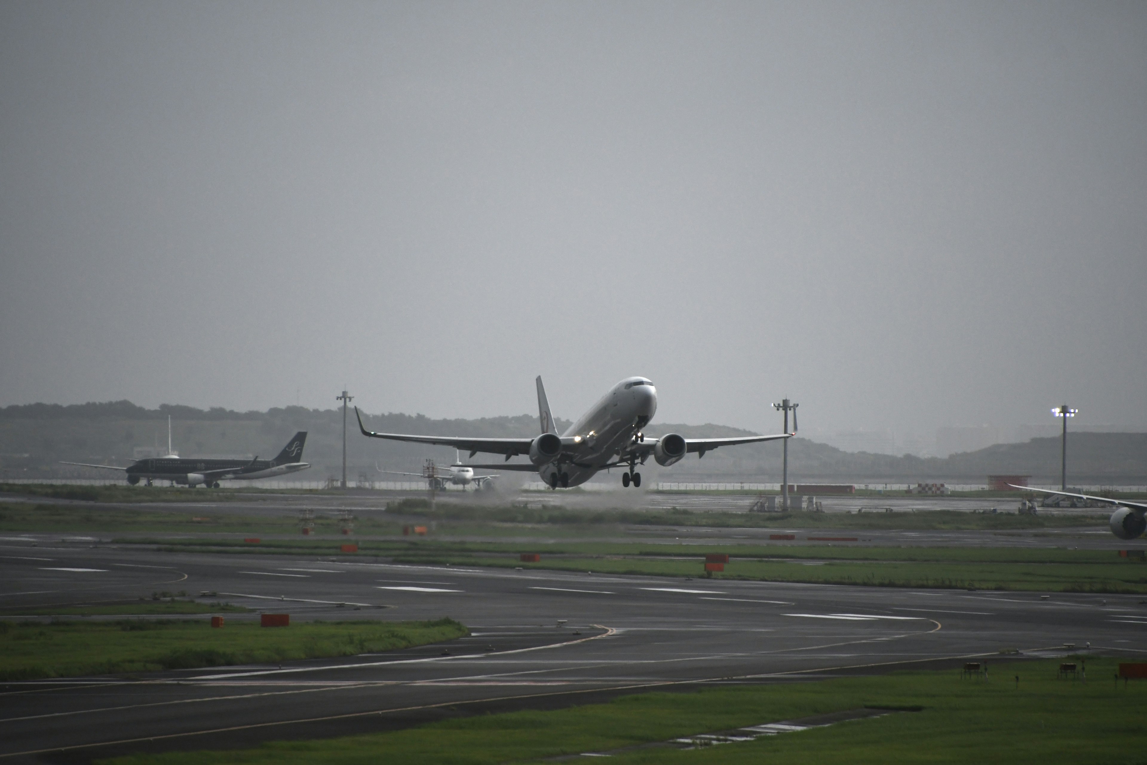 Airplane taking off at an airport under a gray sky