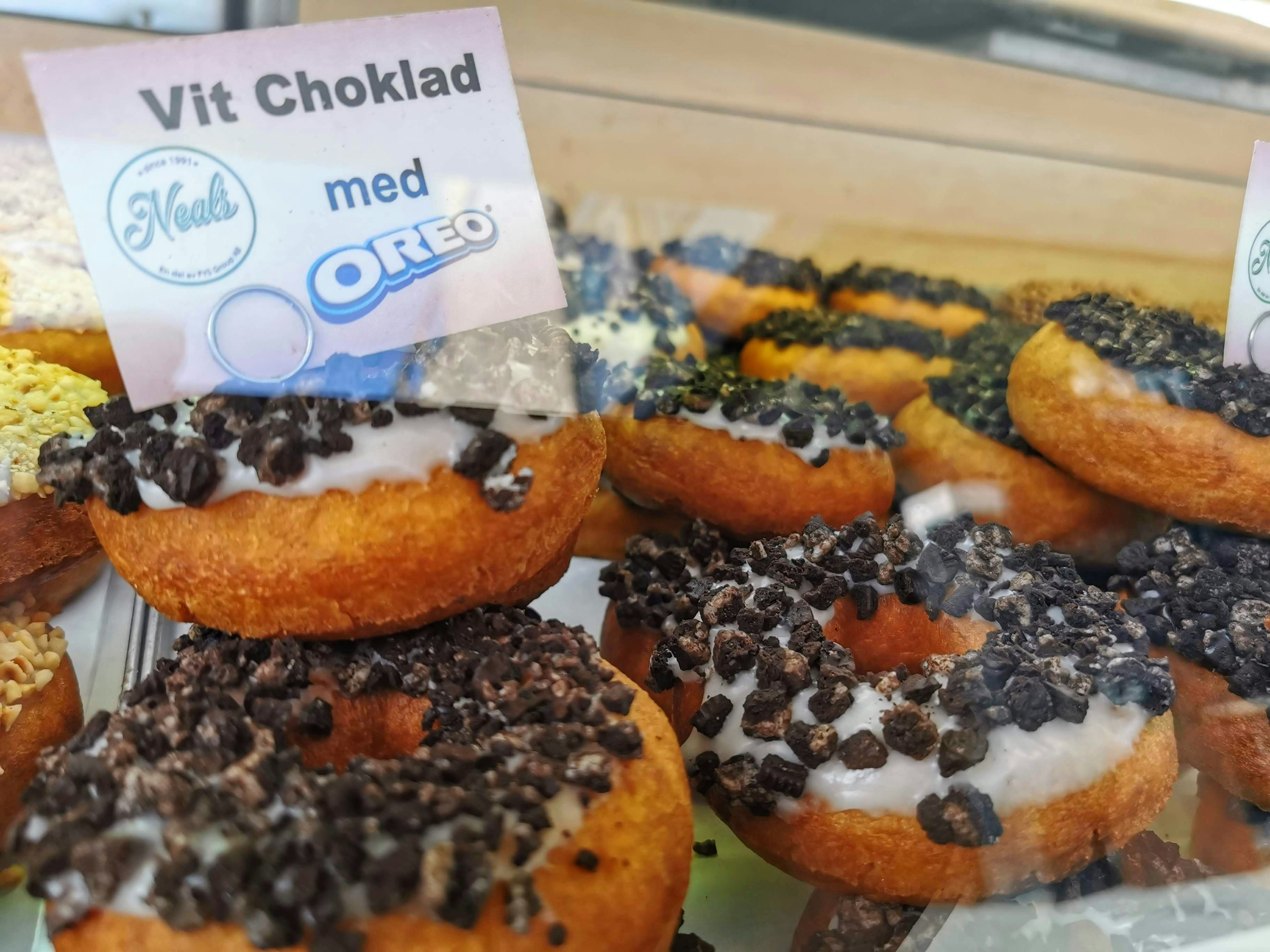 Display of donuts topped with Oreos featuring white chocolate cream