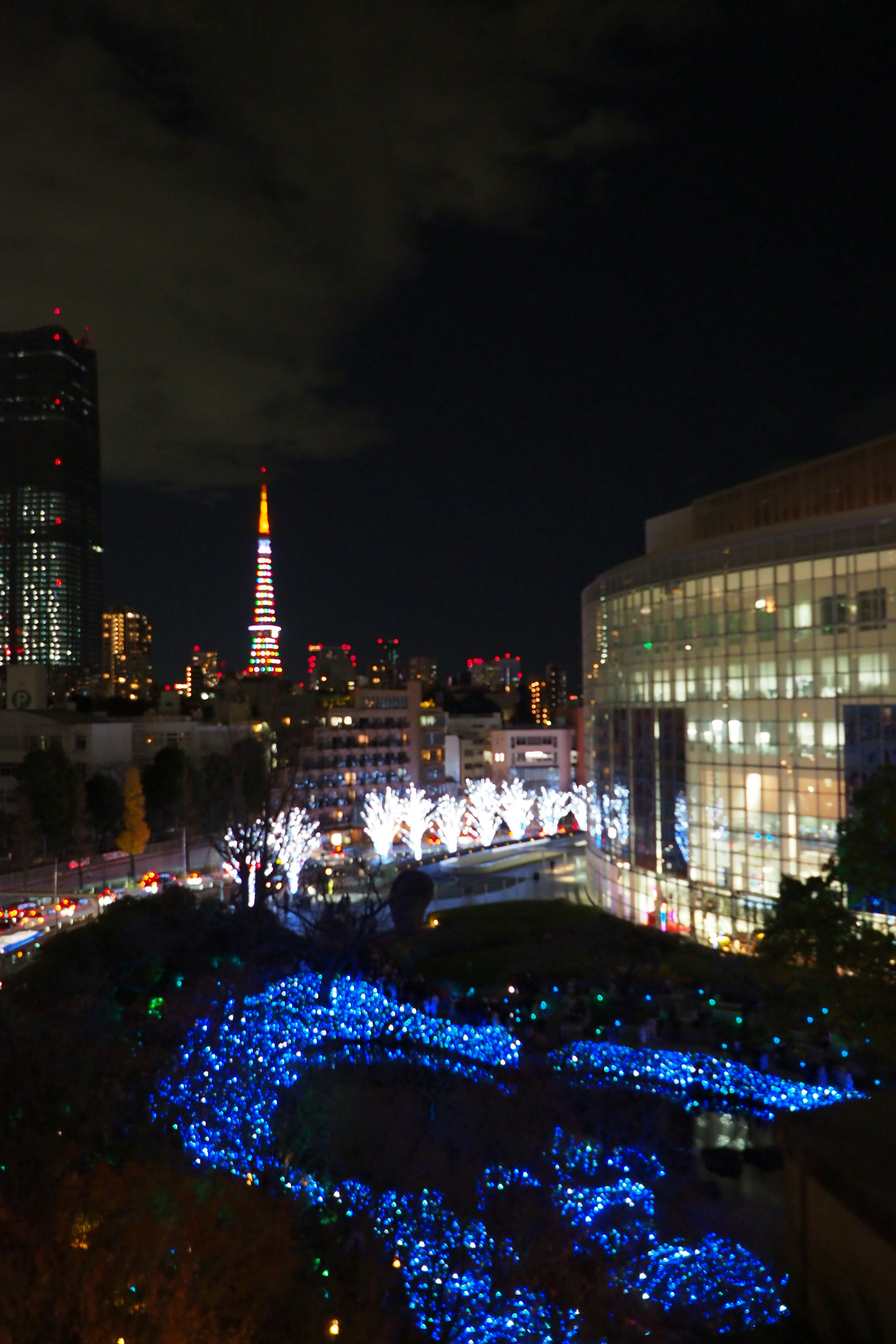 Torre de Tokio iluminada por la noche con luces azules vibrantes en primer plano