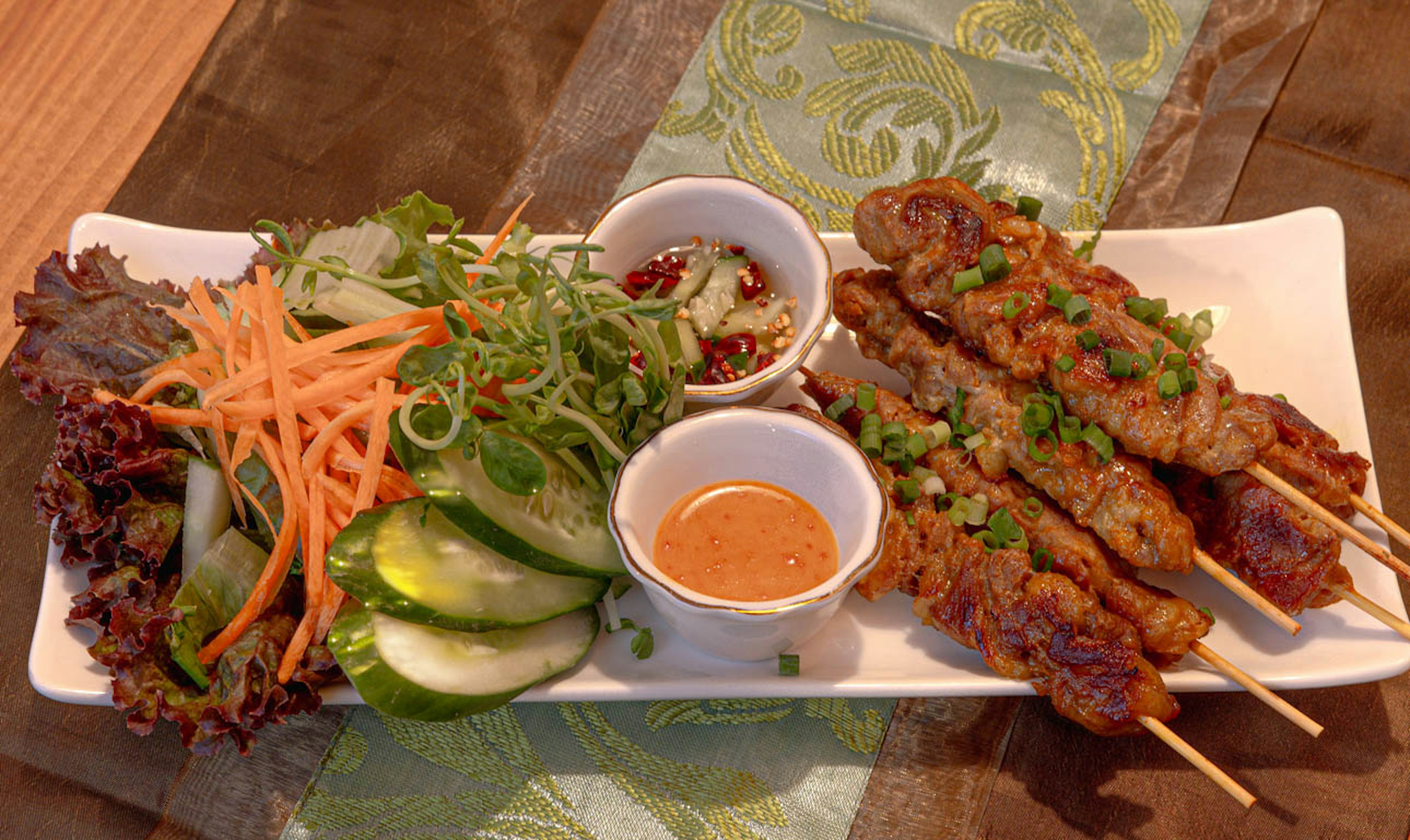 Grilled skewers with fresh salad featuring chicken skewers and dipping sauces