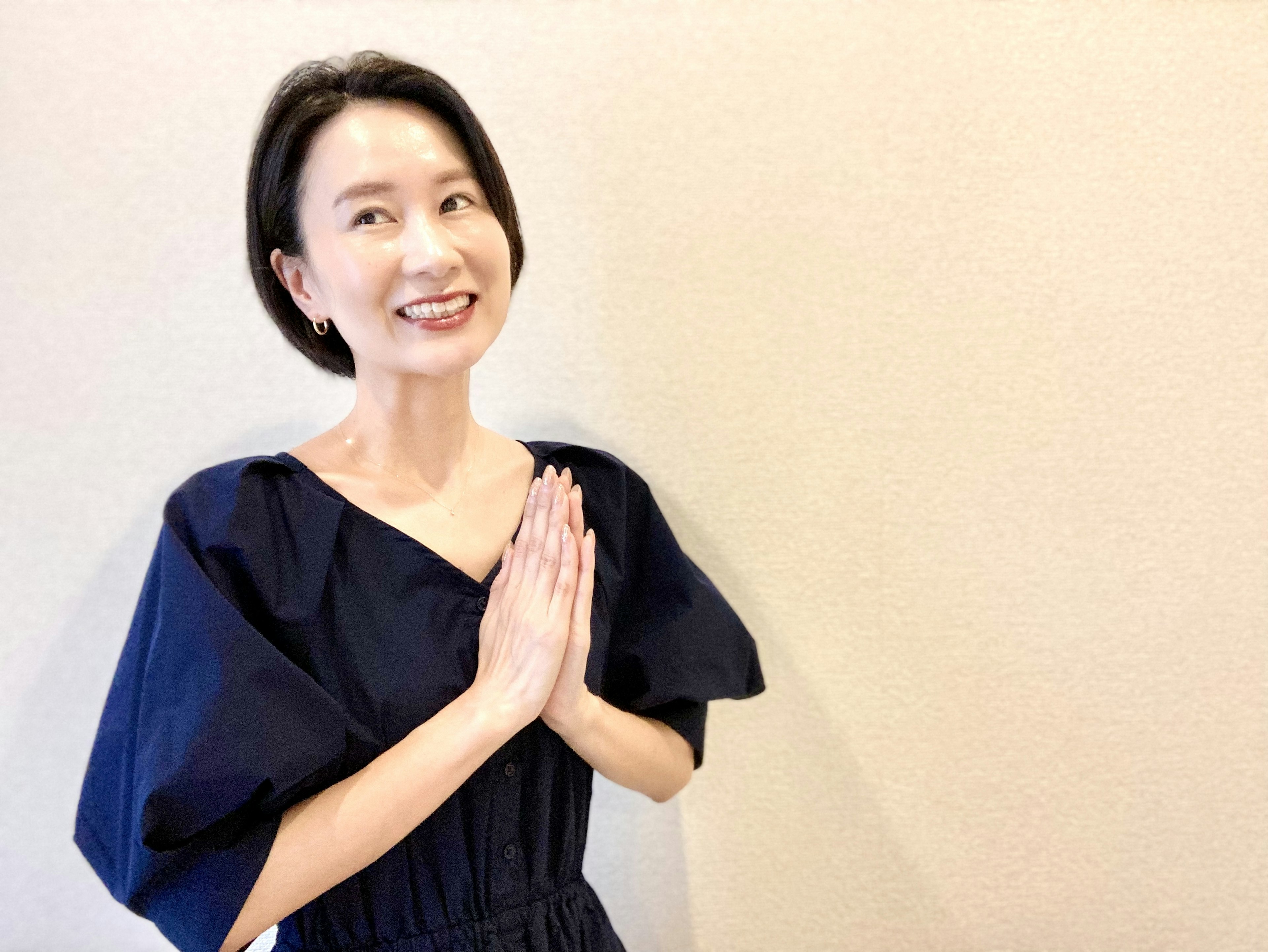 Smiling woman with hands together in a greeting gesture