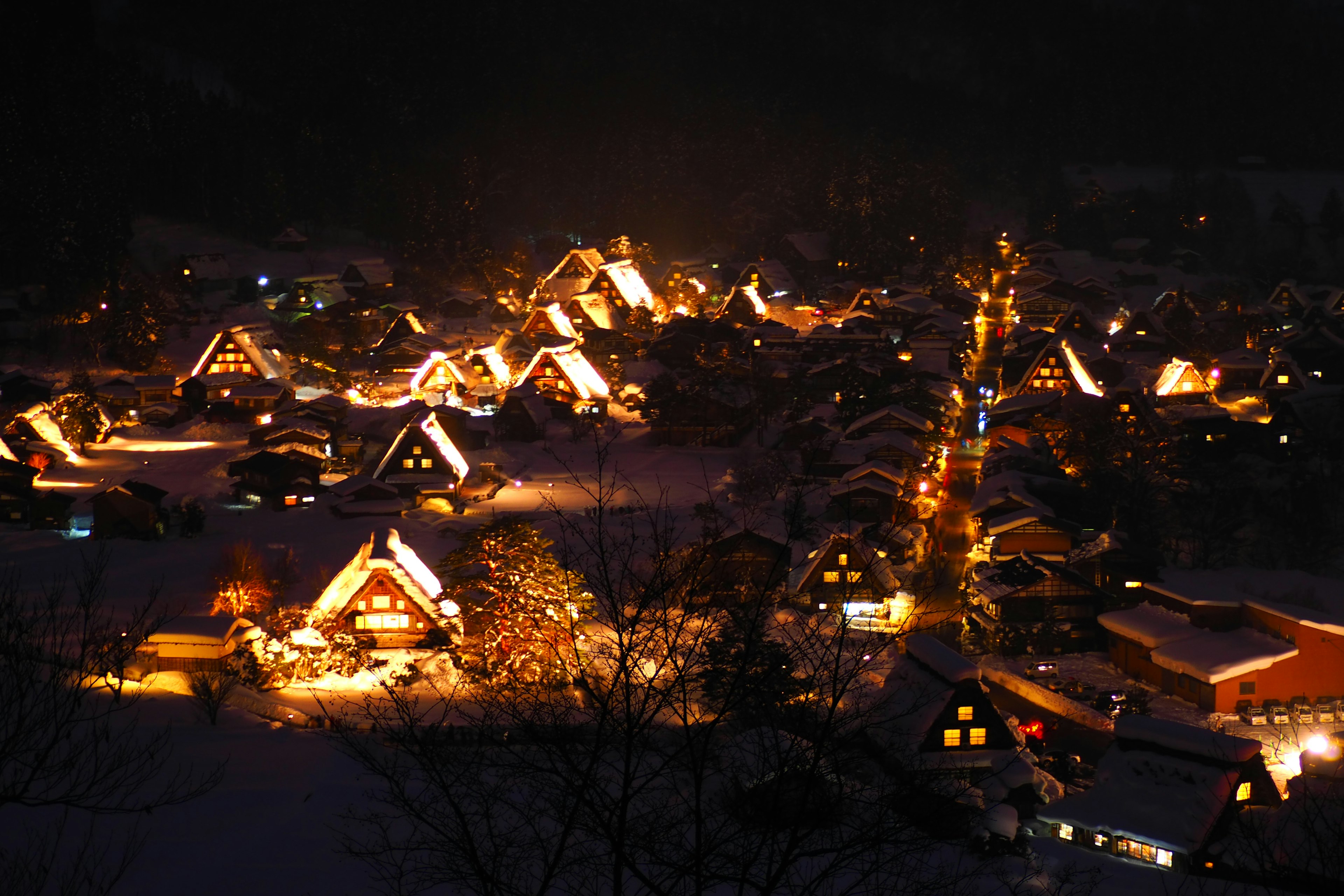 Schöne Nachtansicht eines verschneiten Dorfes mit beleuchteten traditionellen Gassho-Zukuri-Häusern