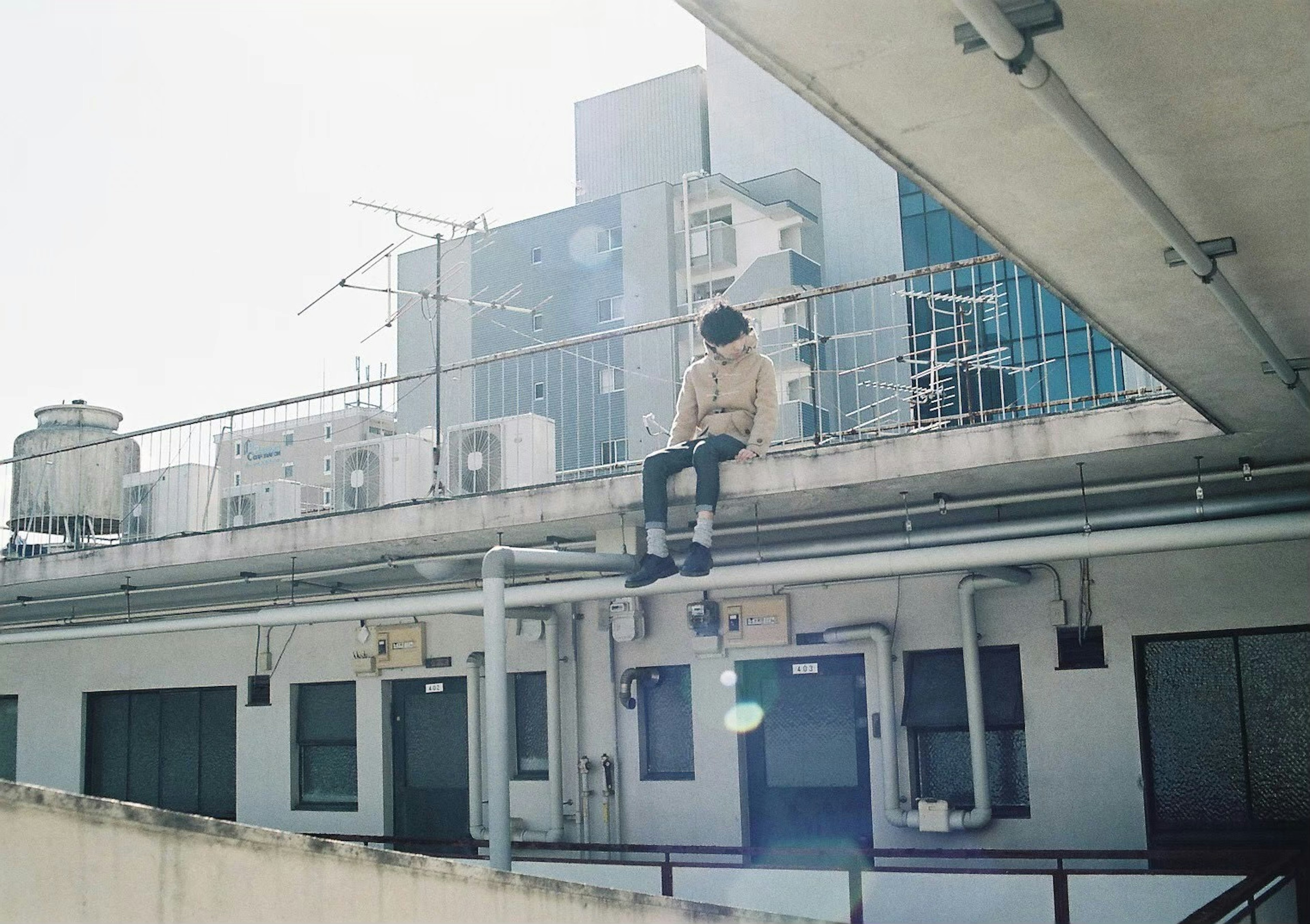 屋上で座っている人物と都市の建物