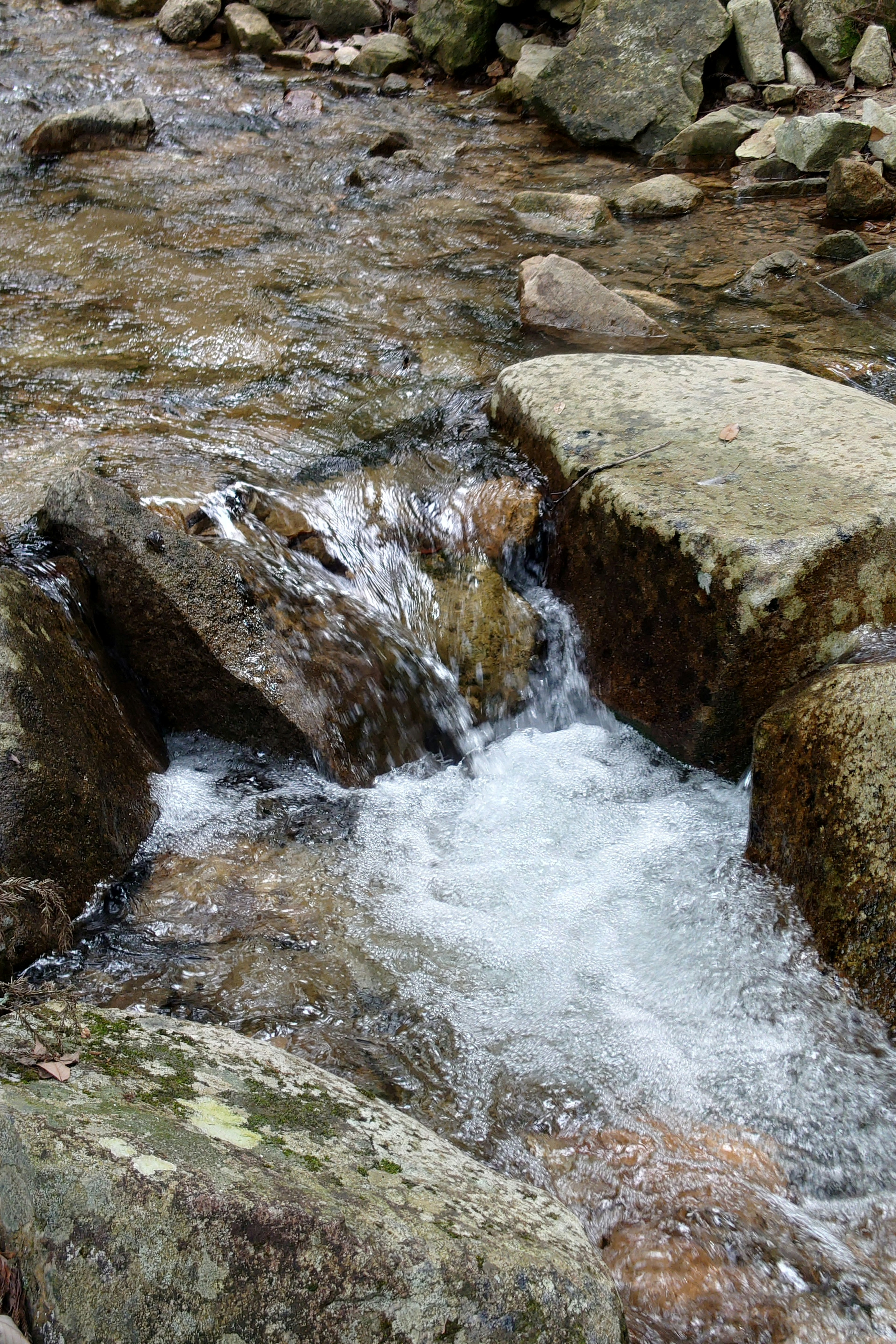 Pemandangan indah aliran sungai di atas batu