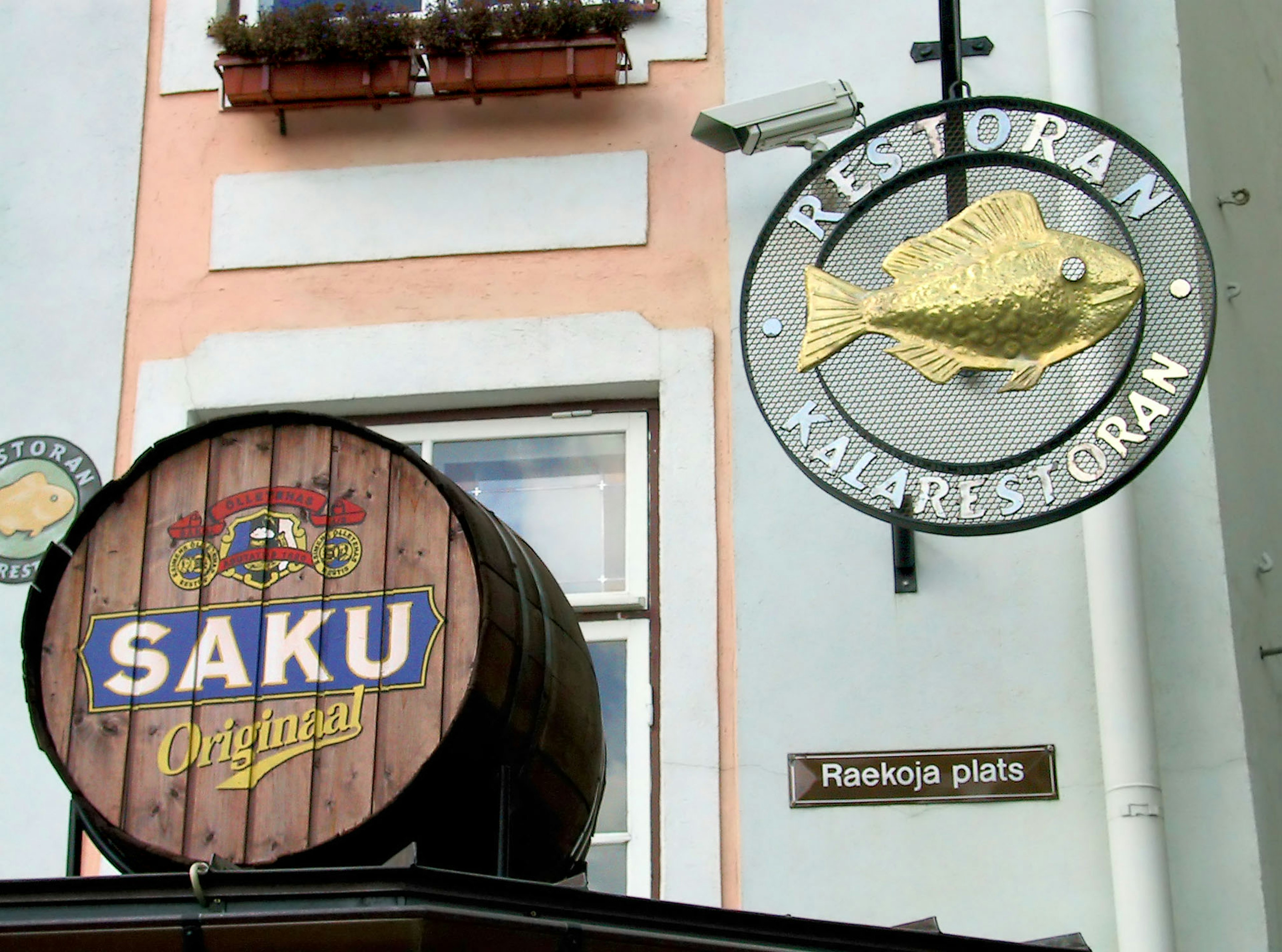 Außenansicht eines Restaurants mit einem Holzfass mit Saku und einem Fischschild