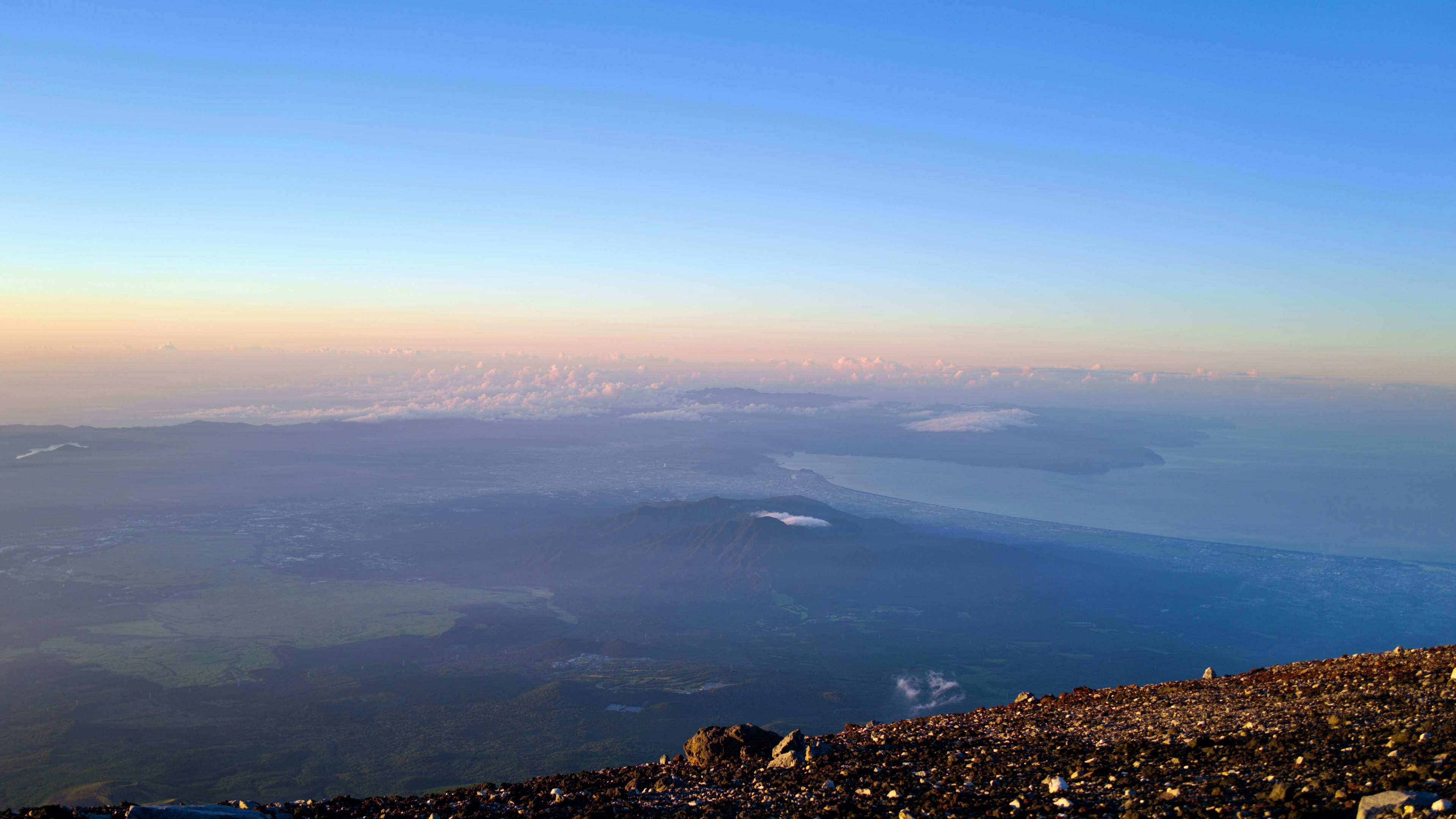 Impresionante vista desde la cima de una montaña con cielo azul y un mar de nubes