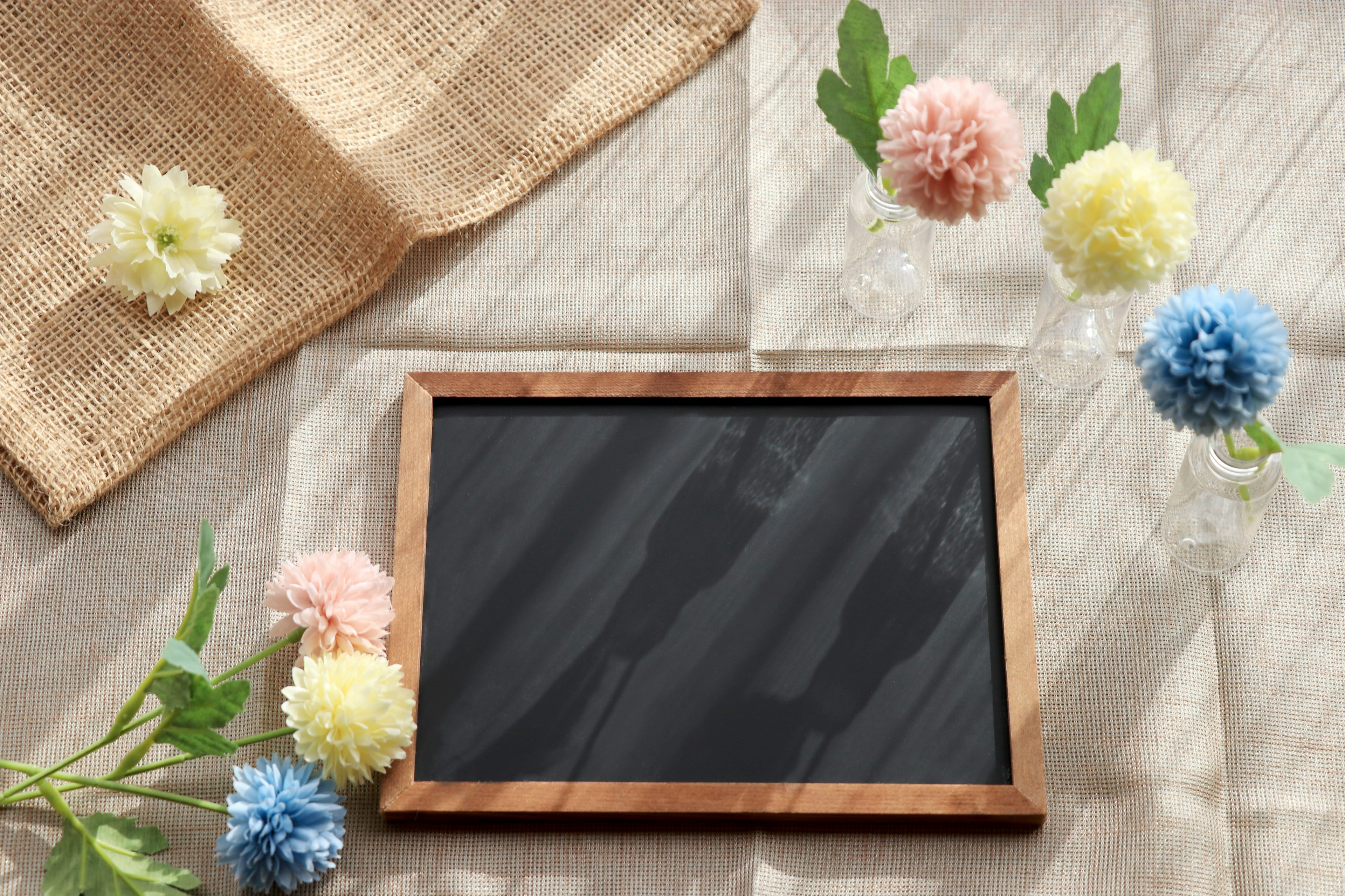 Tableau noir en bois au centre avec des fleurs colorées disposées autour