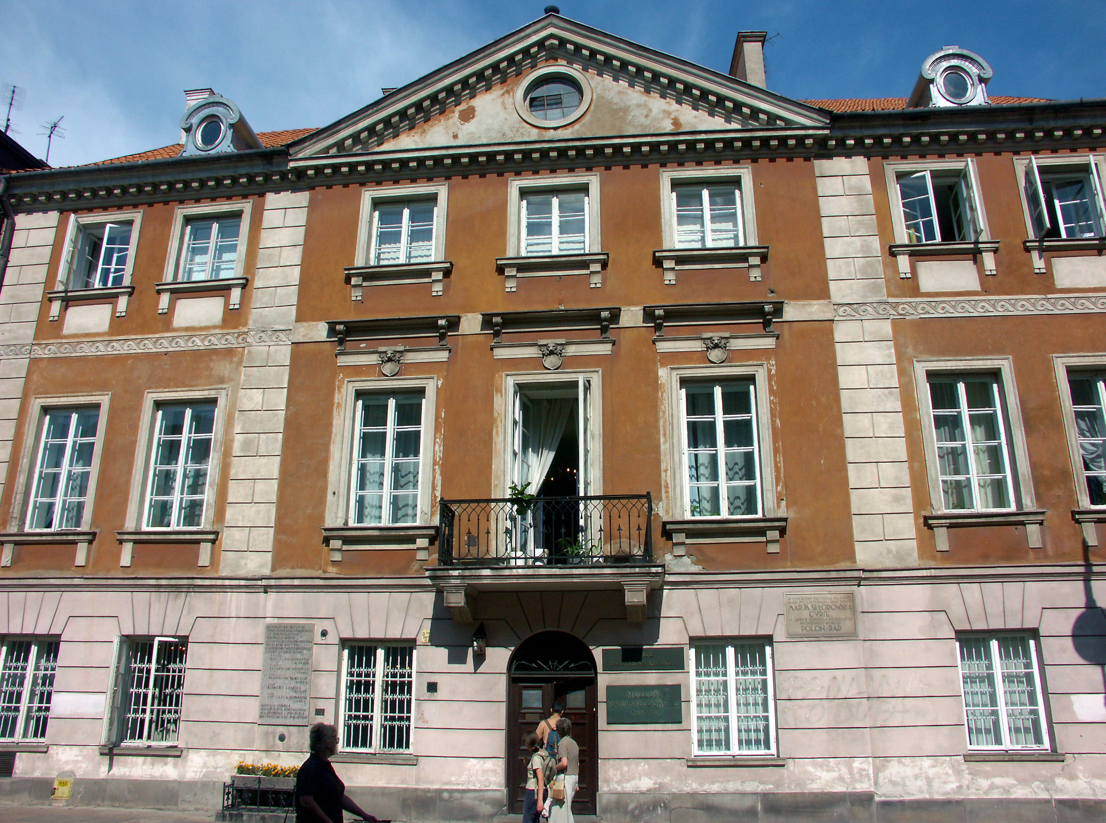 Facade of a historic building with orange walls and white window frames