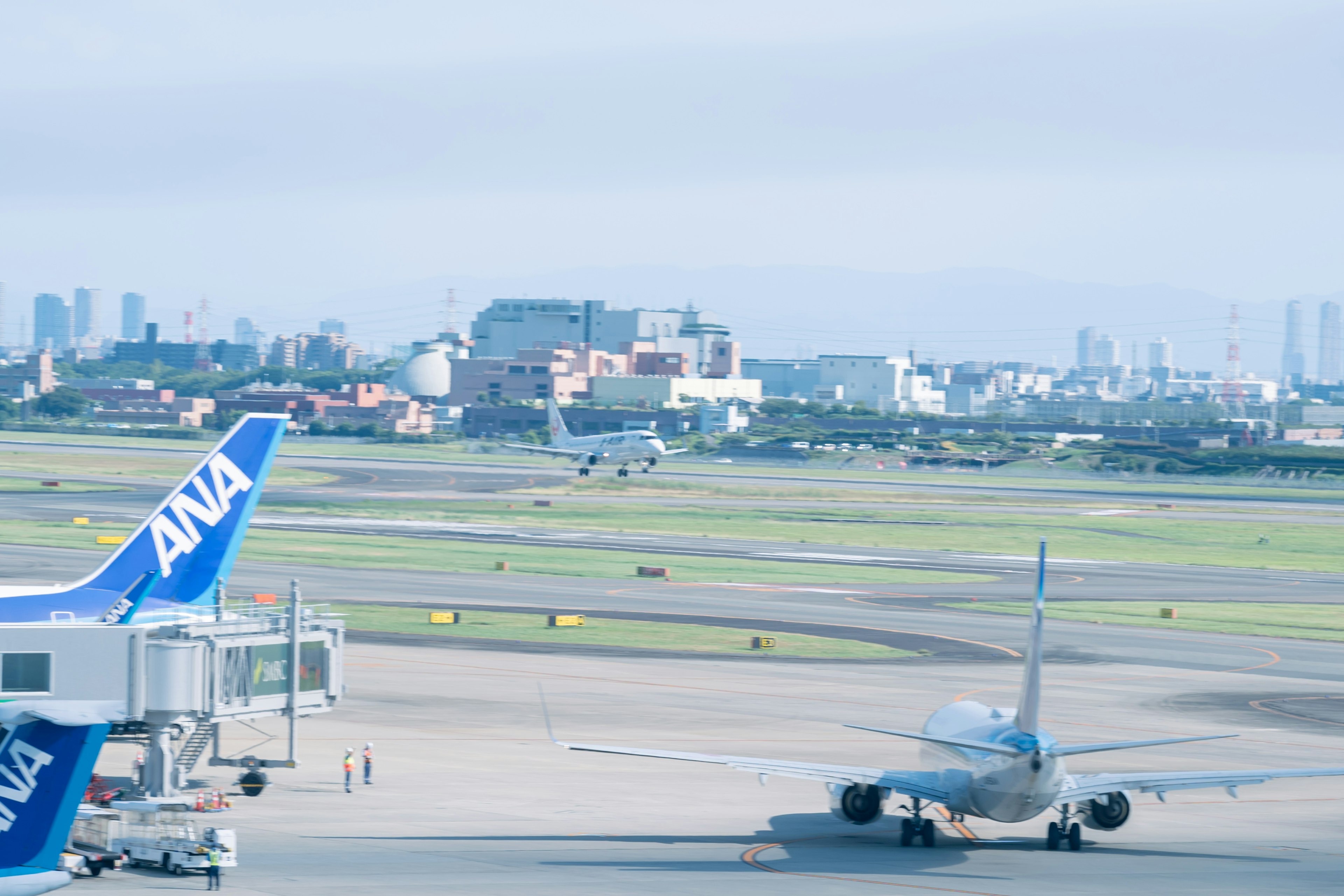 空港の滑走路で飛行機が離陸する様子とANAの航空機