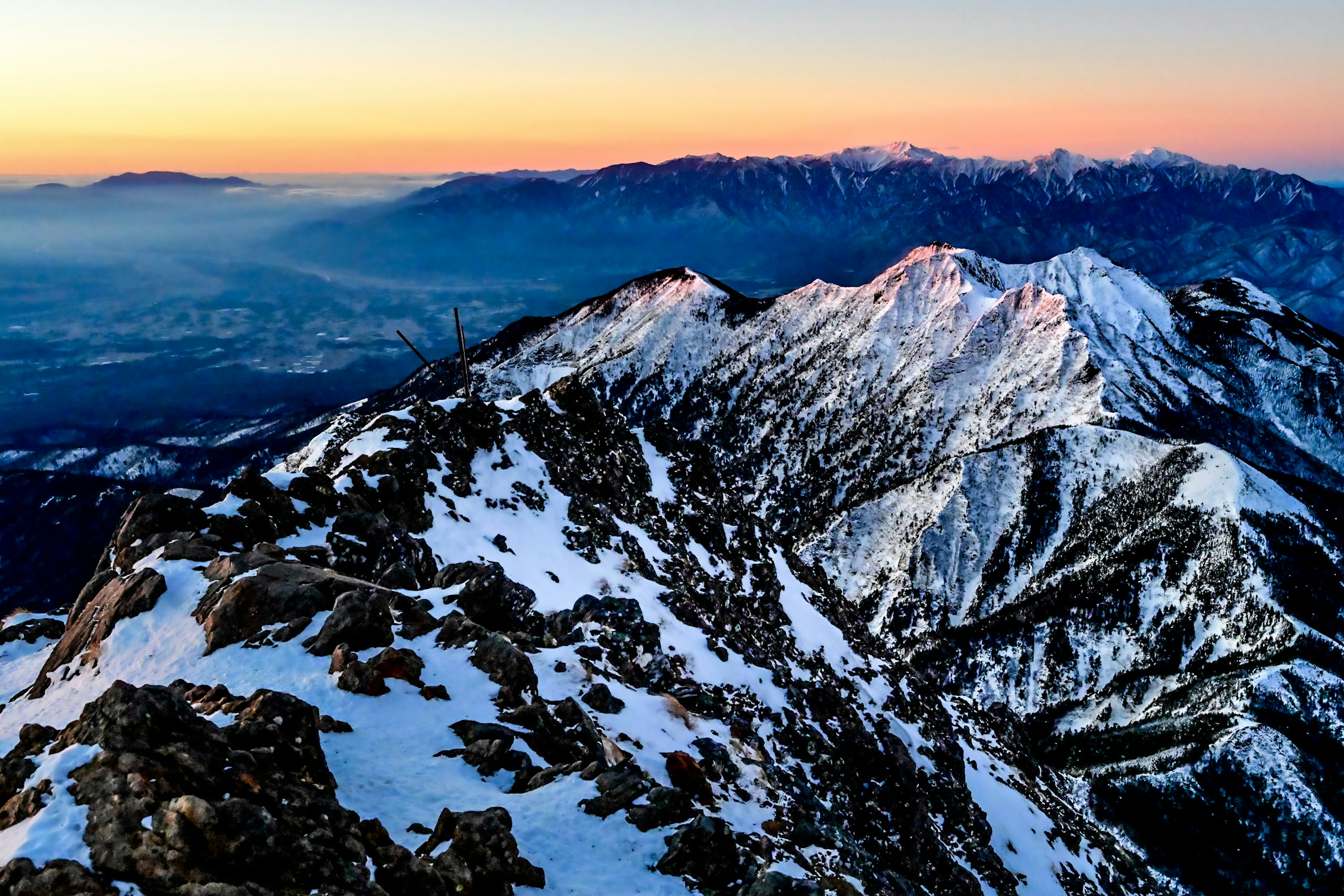 Snow-covered mountain range with a stunning sunset