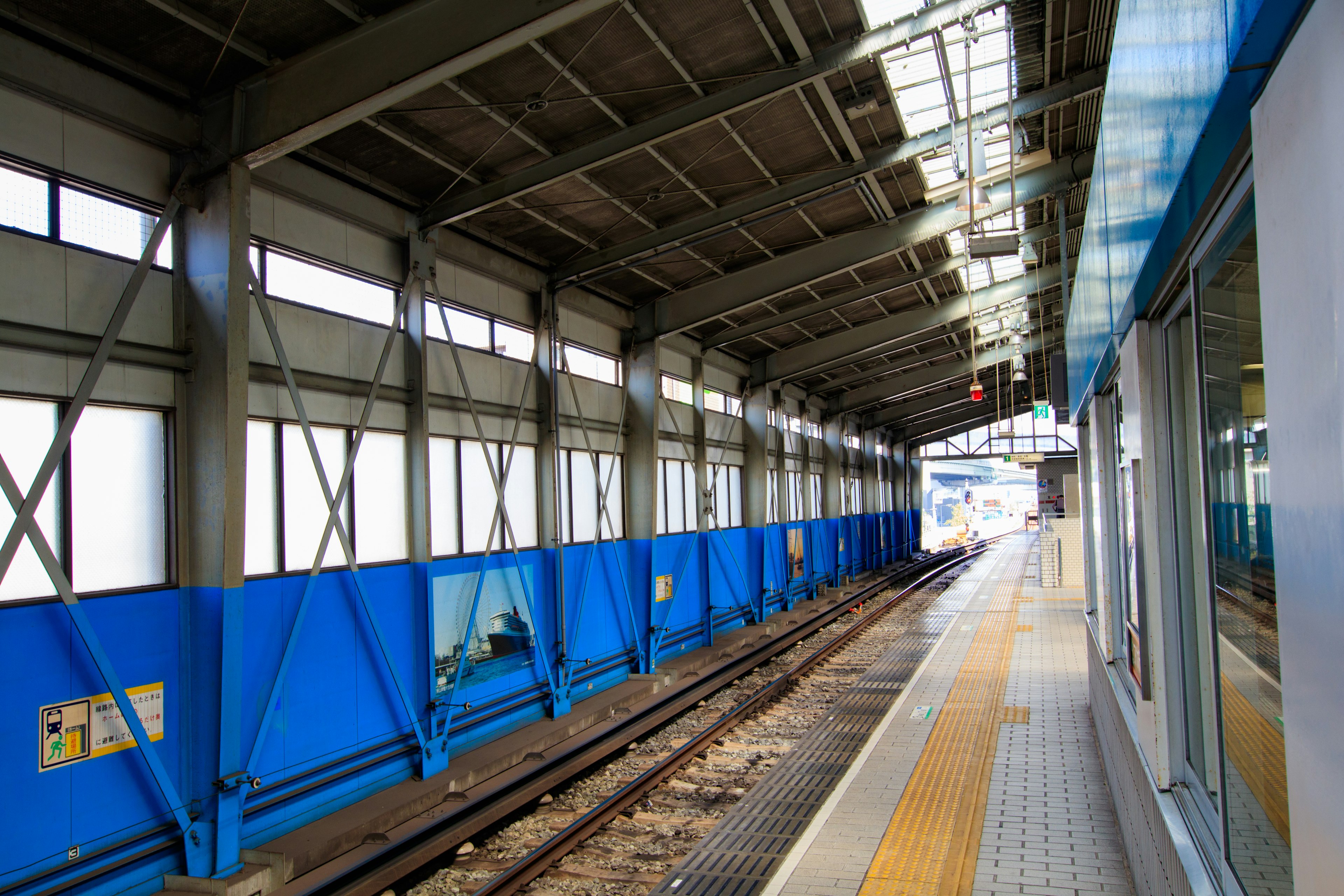 View of a train station platform with blue walls and roof