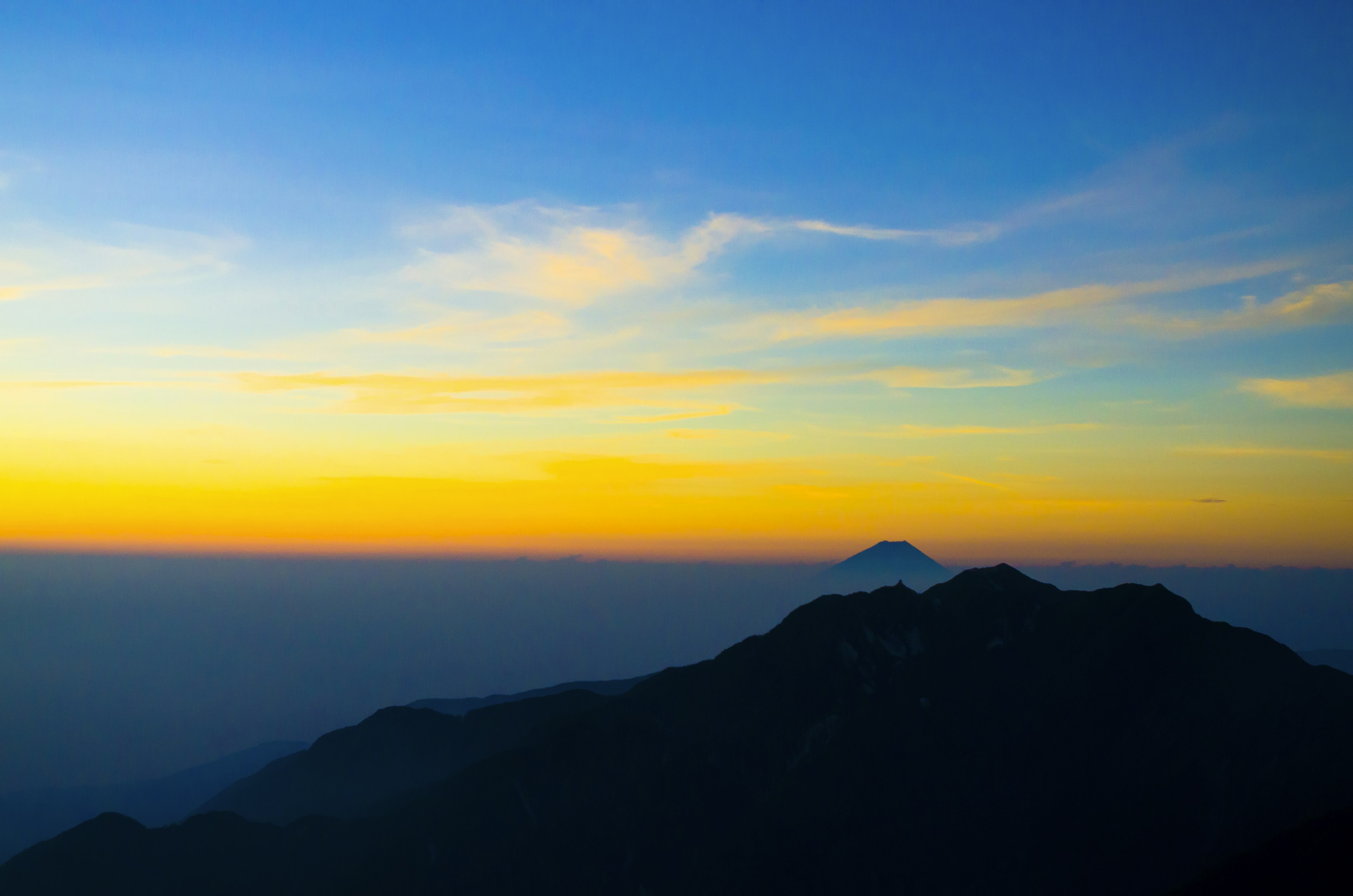 Wunderschöner Sonnenuntergangshimmel mit Silhouetten von Bergen