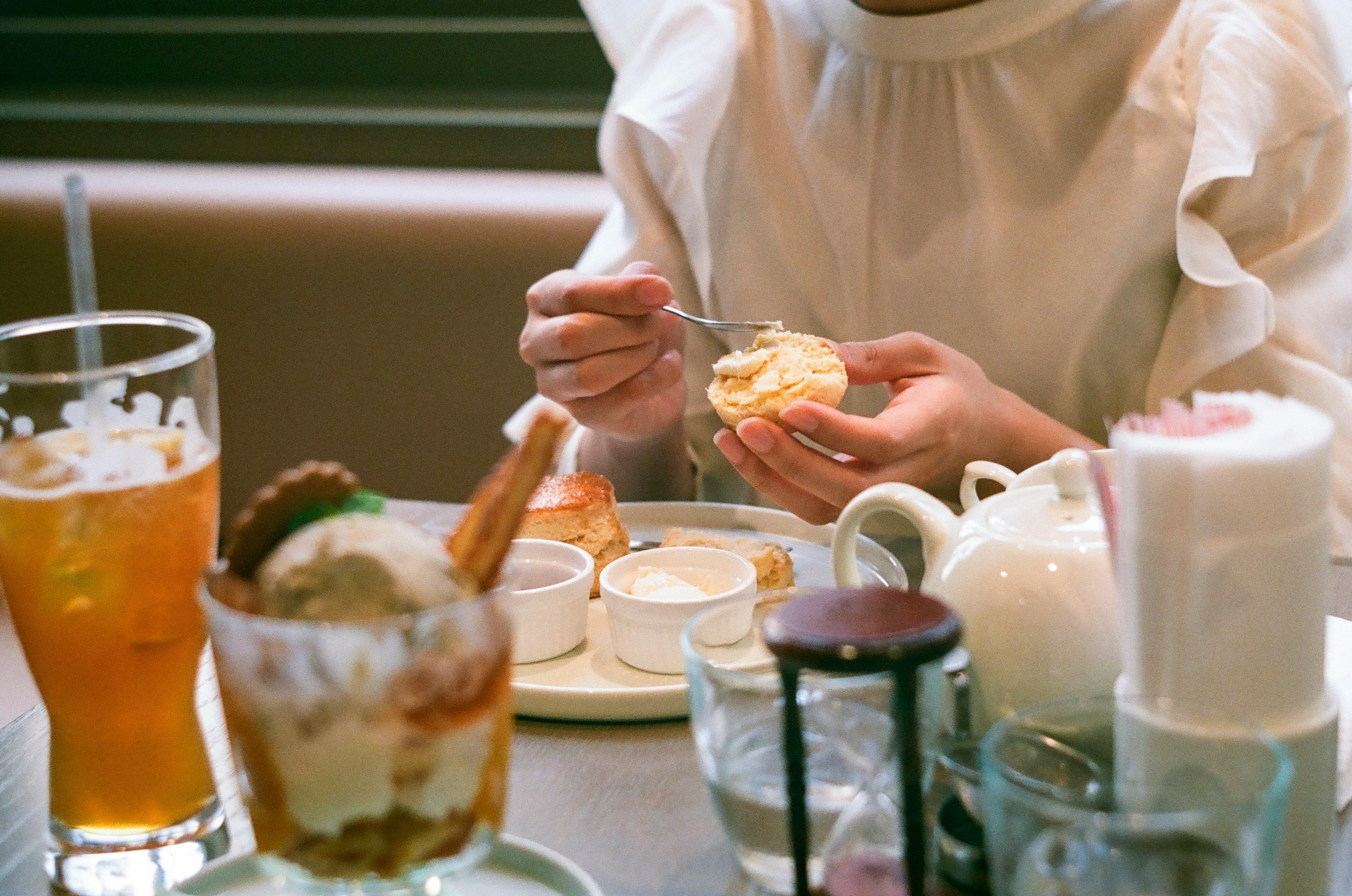 Una mujer disfrutando de un postre en un café con varias bebidas