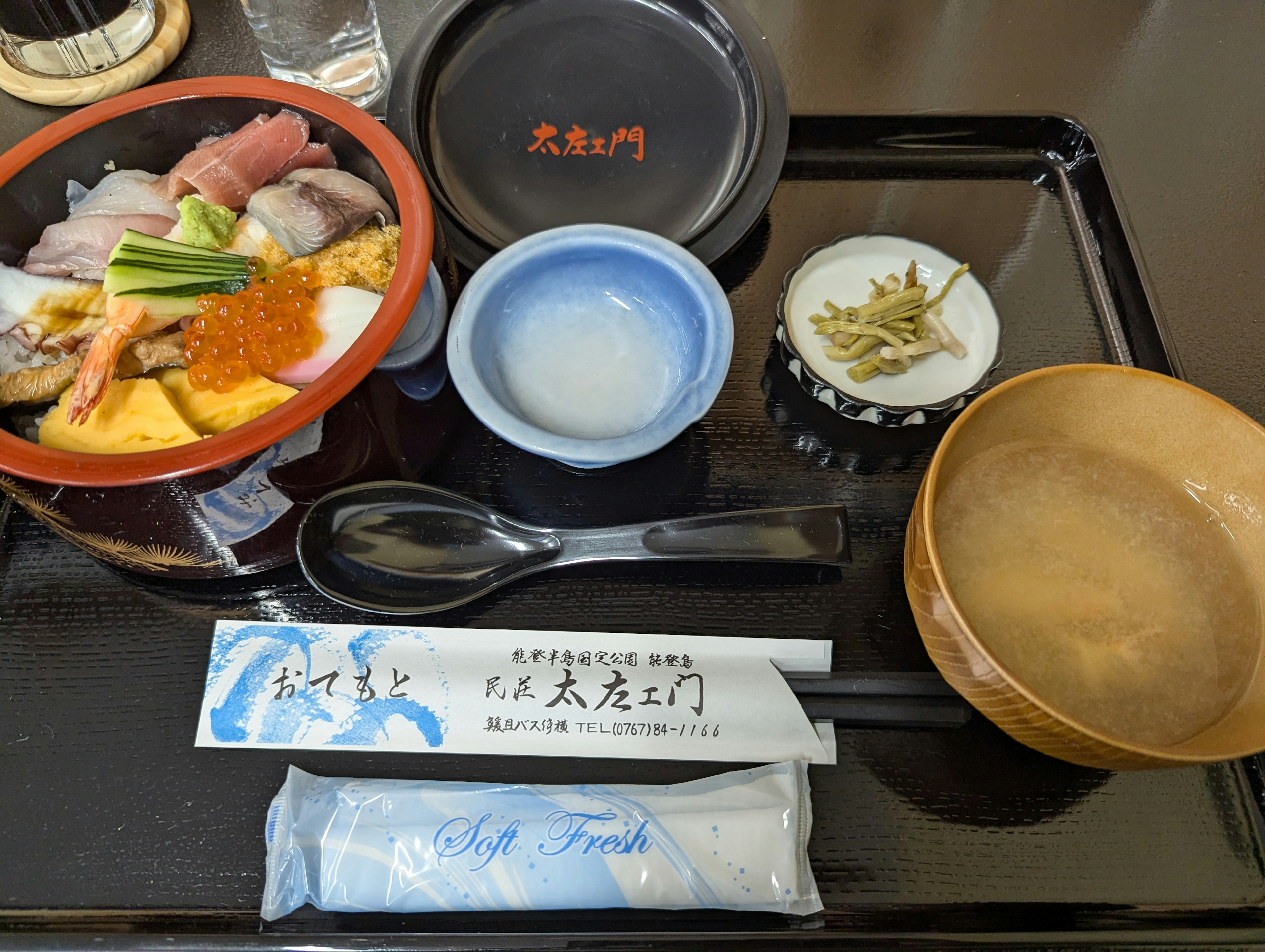 Colorful sushi and sashimi arranged on a Japanese dining plate with miso soup