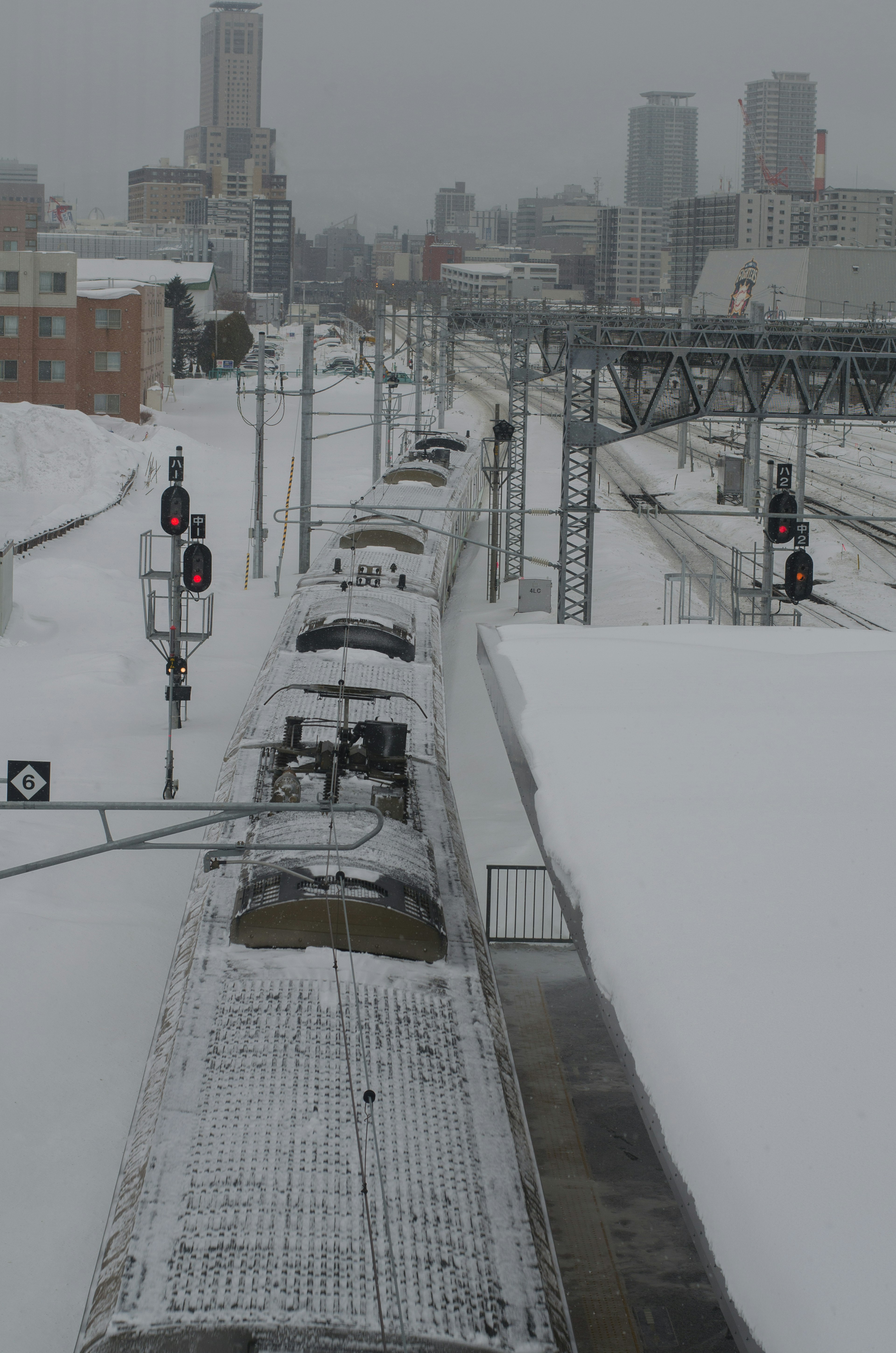 รางรถไฟที่ปกคลุมไปด้วยหิมะพร้อมรถไฟที่จอดอยู่