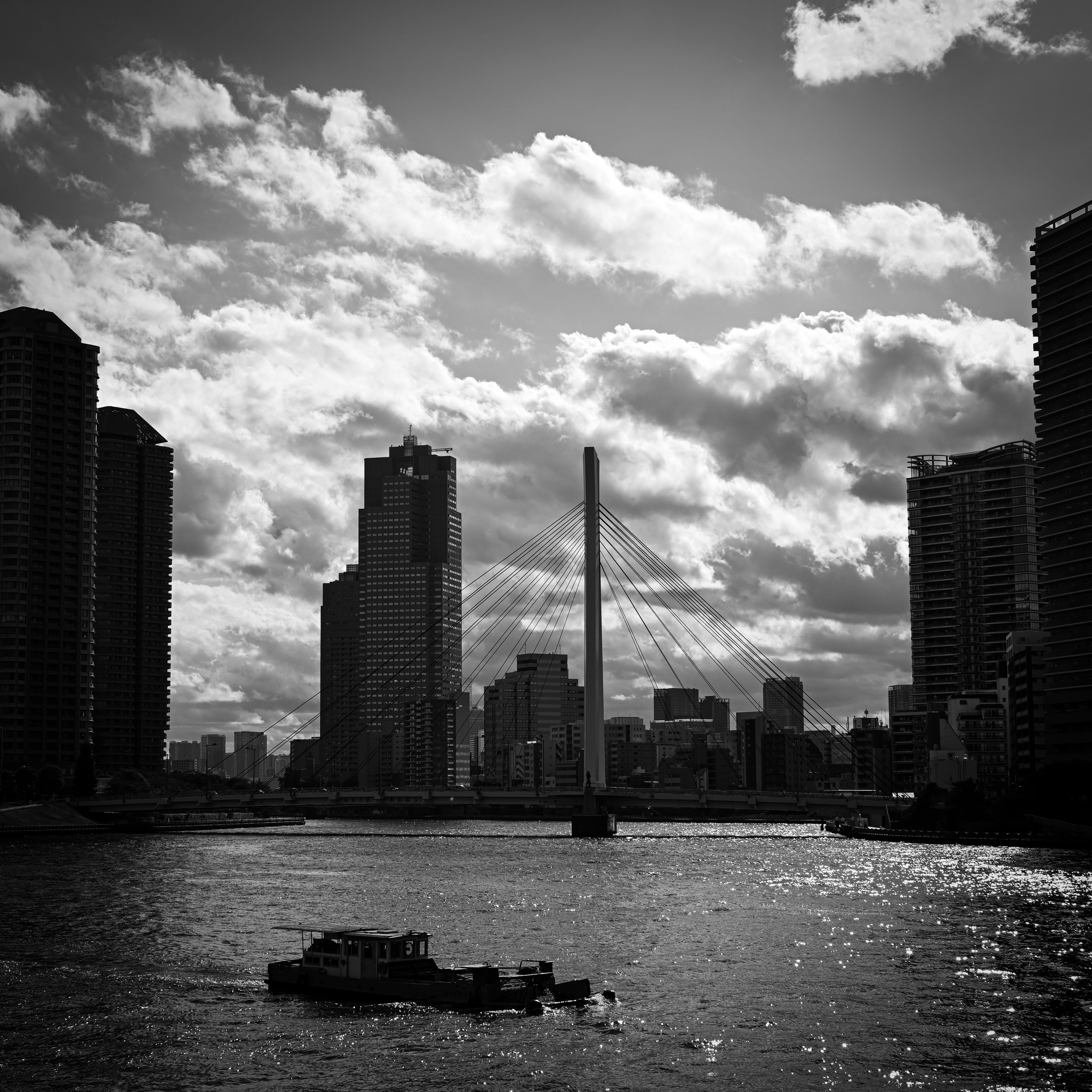 Black and white cityscape featuring tall buildings and a river